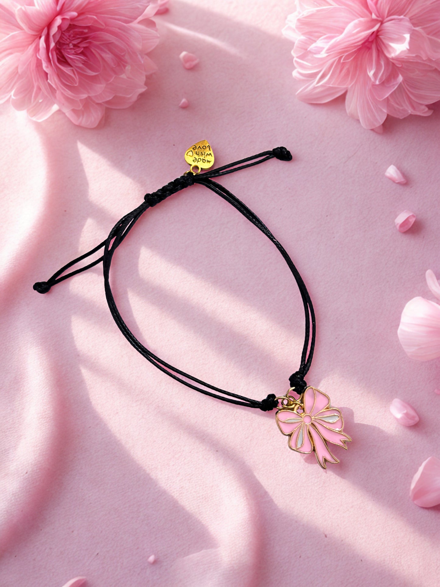 Bracelet with pink bow charm on a pink background with flowers