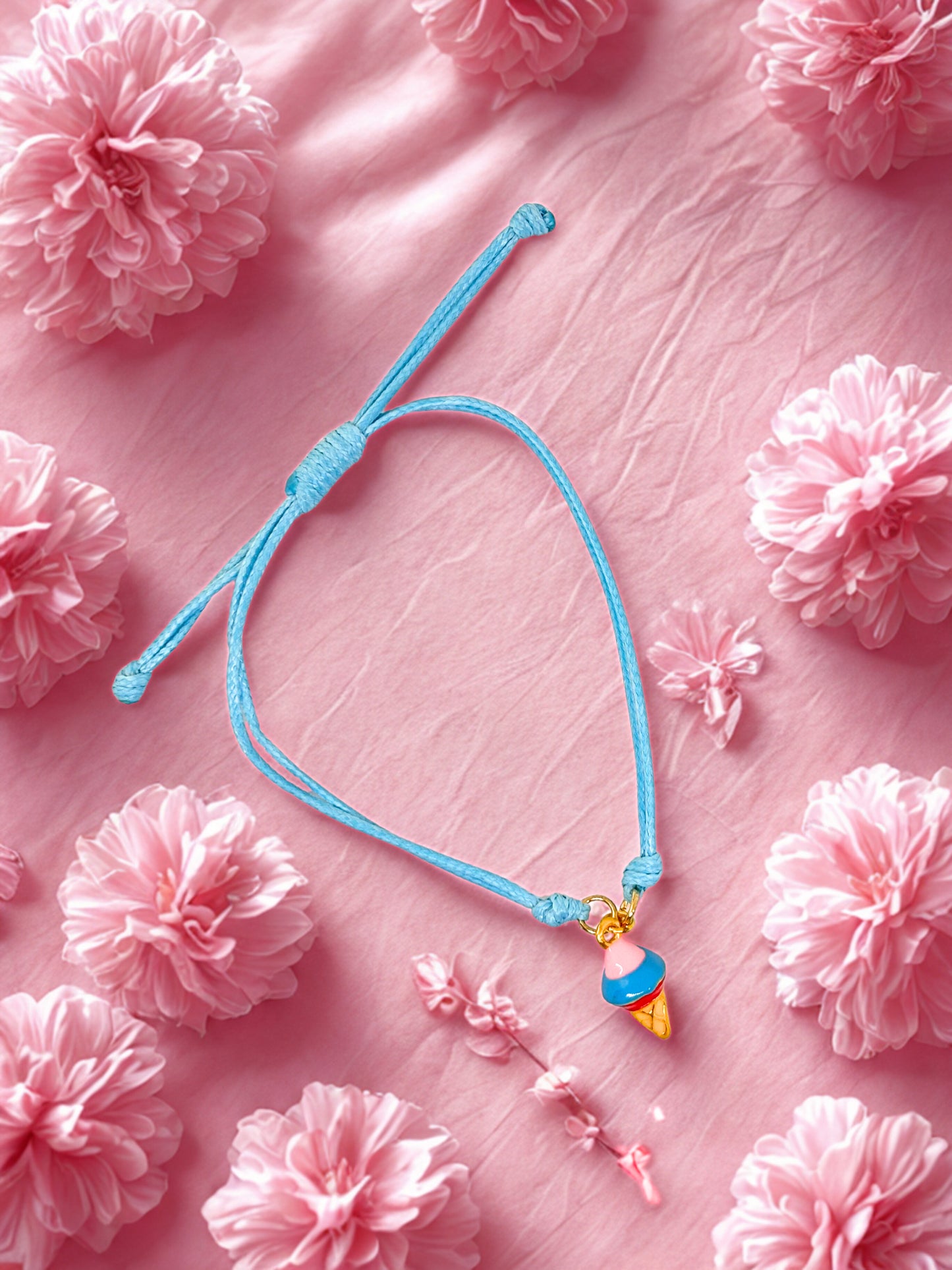 Blue bracelet with a colorful ice cream charm on a pink floral background