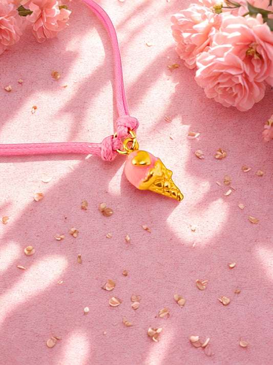 Pink charm bracelet with a gold ice cream cone charm on a pink background with flowers and petals.