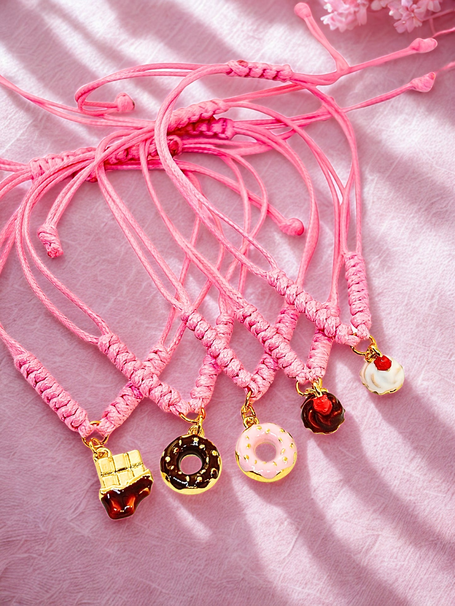 pink cord bracelets with dessert charms. Cupakes, donuts and chcolate bar