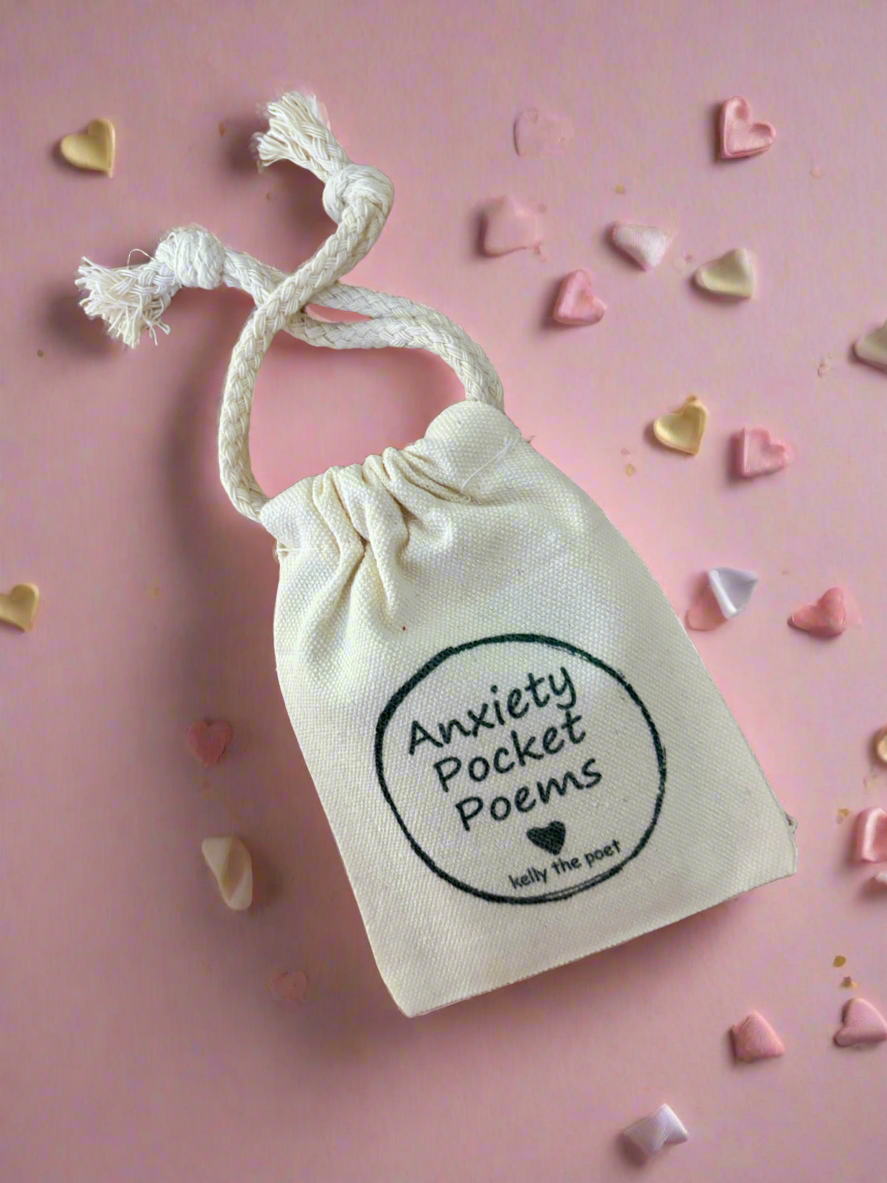 Small beige drawstring bag with 'Anxiety Pocket Poems' text on a pink background with heart-shaped objects.