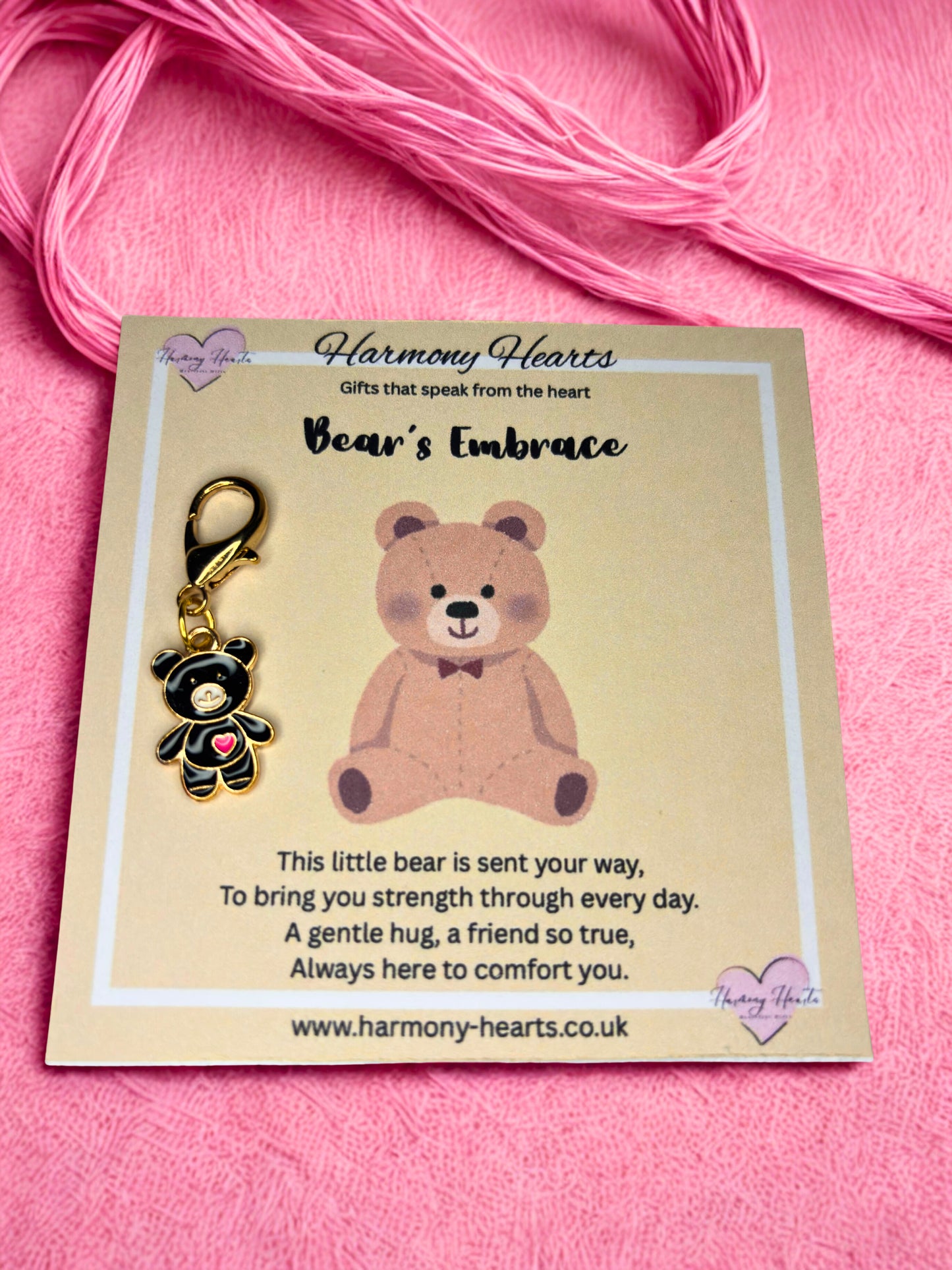 Bear-shaped keychain on a card with 'Harmony Hearts' branding against a pink background