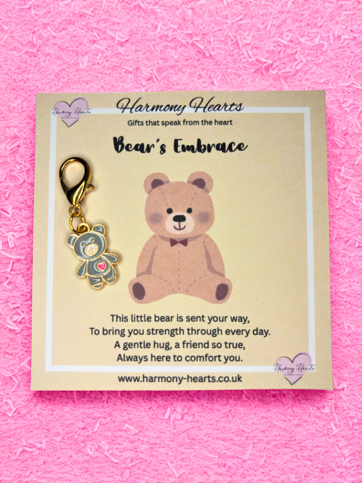 Bear-shaped keychain with card on a pink background