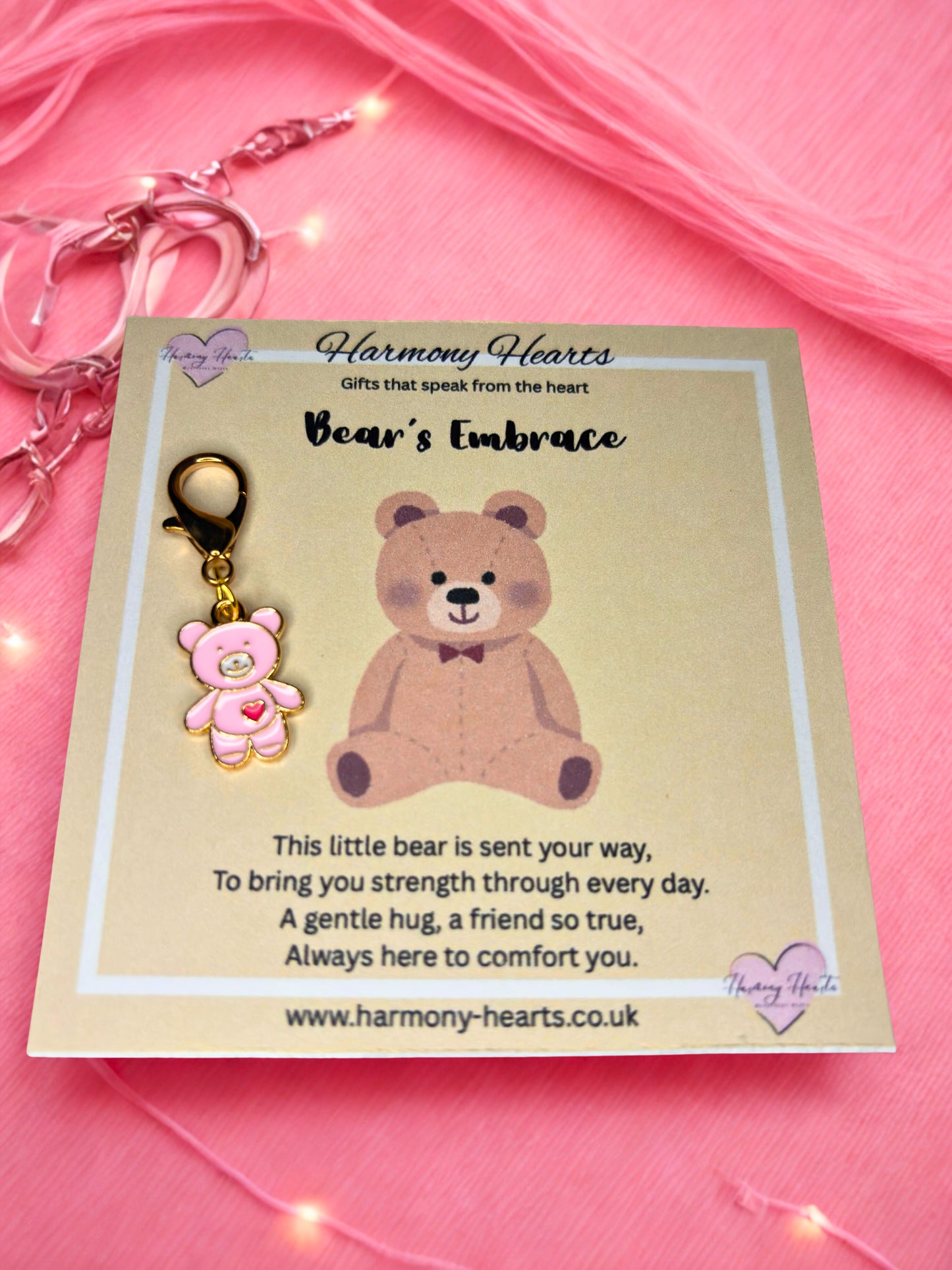 Bear-shaped keychain on a card with pink background