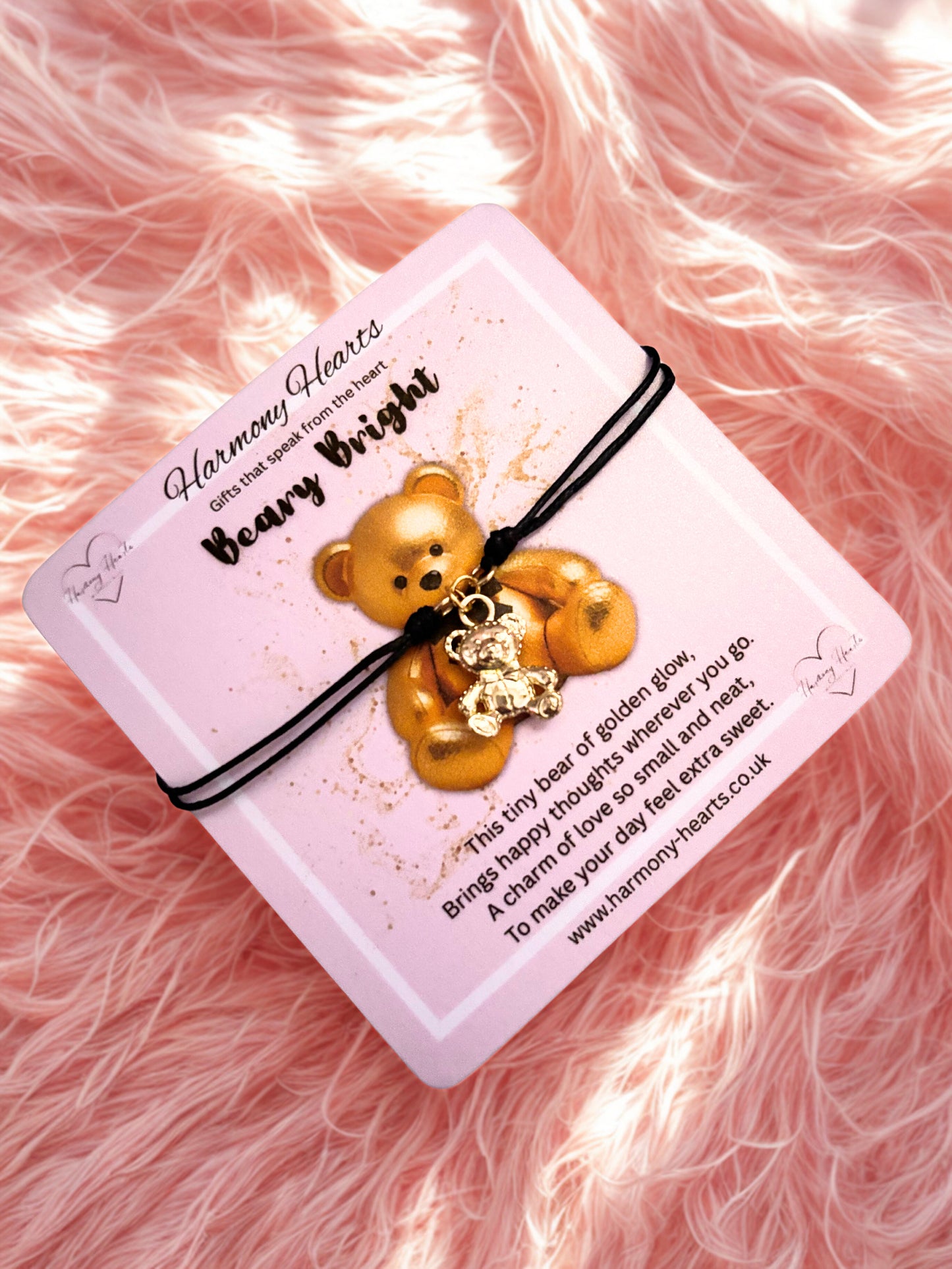 Teddy bear charm on a pink card with text on a pink fluffy background
