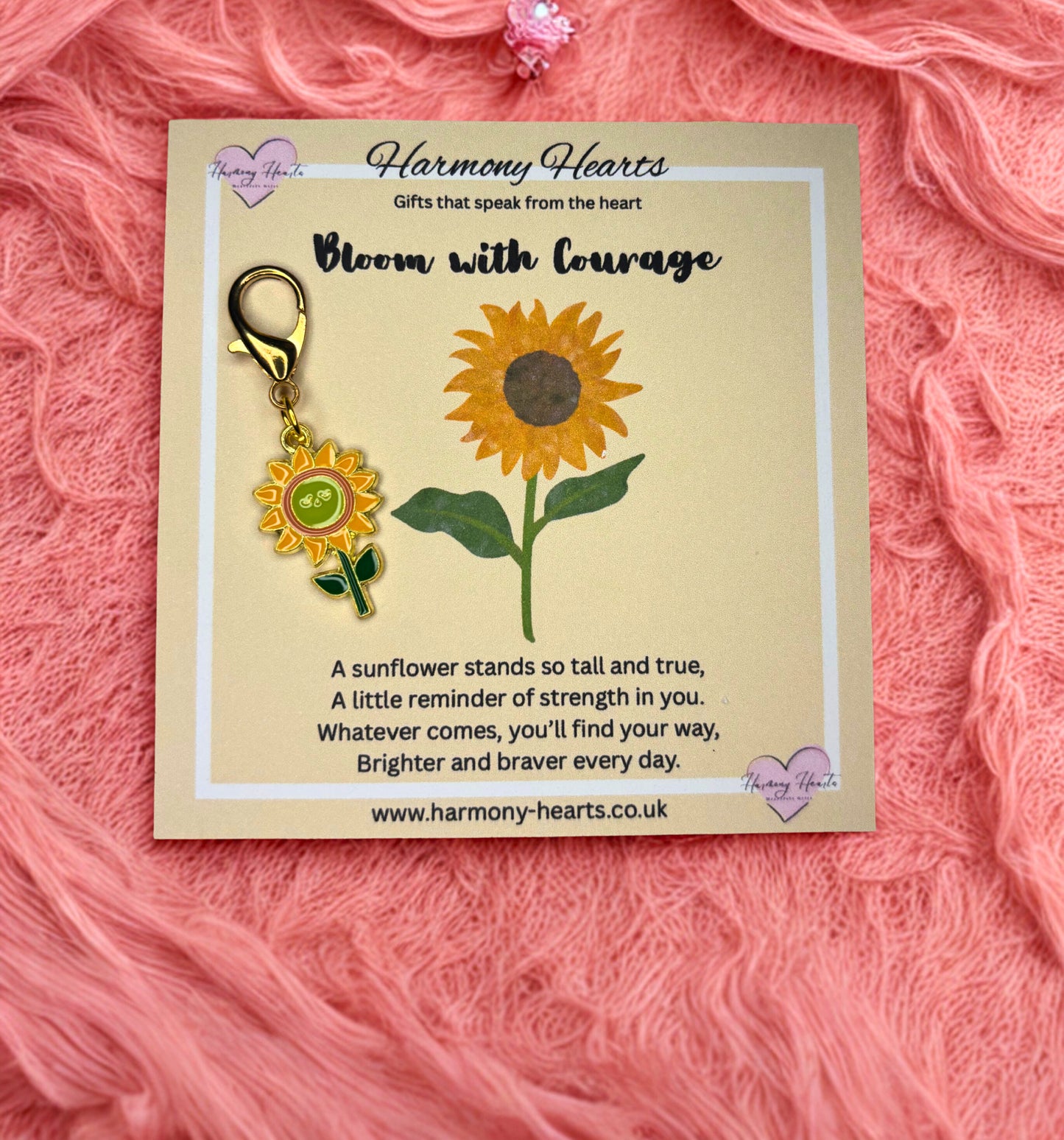Sunflower-themed keychain on a 'Harmony Hearts' card with a pink textured background