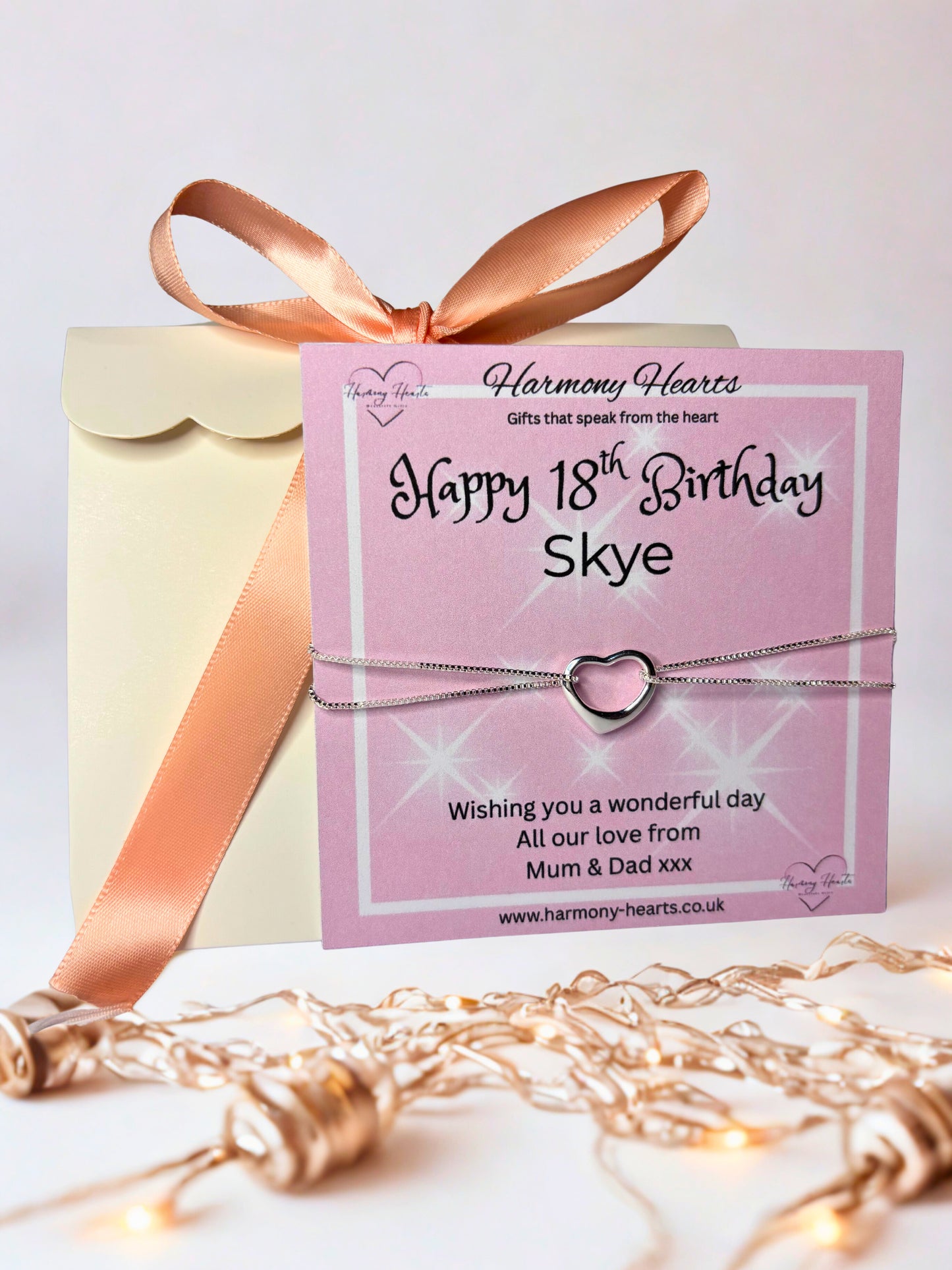 Gift box with pink ribbon and 'Happy 18th Birthday Skye' card, featuring a heart-shaped bracelet.
