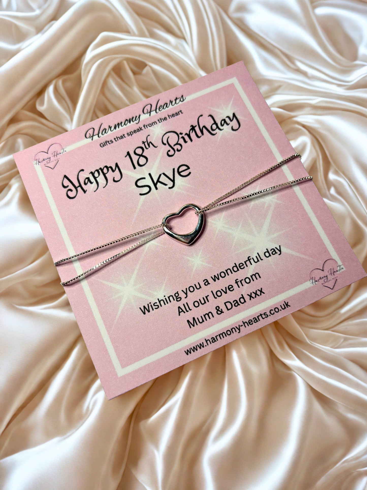 Heart-shaped bracelet on a 'Happy 18th Birthday Skye' card with pink packaging.