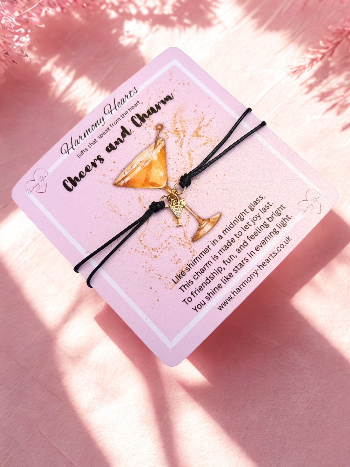 Bracelet with gold cocktail charm on a pink poem card with text