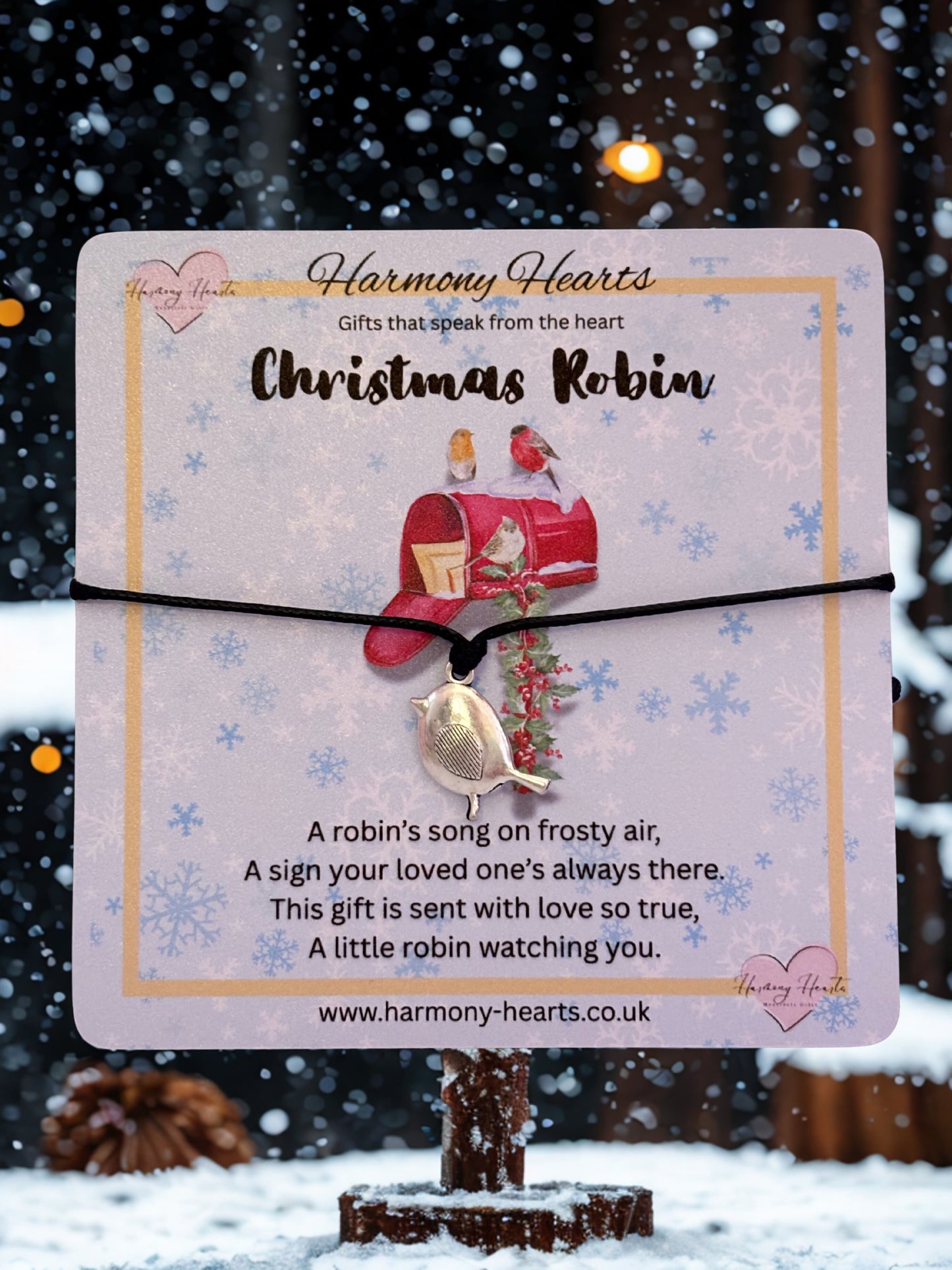 Christmas robin-themed bracelet on a decorative card with a snowy background