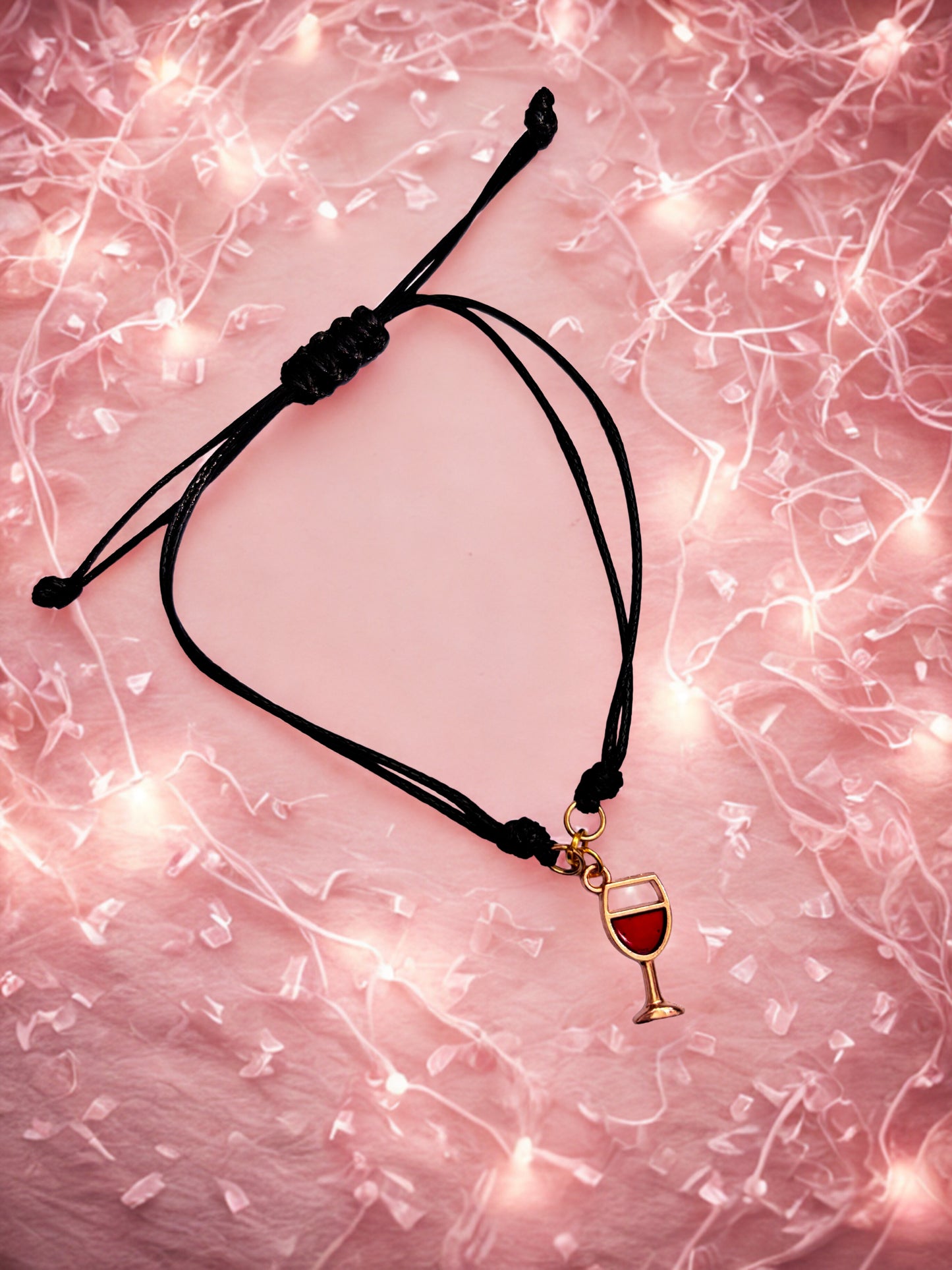 Bracelet with a wine glass charm on a pink textured background