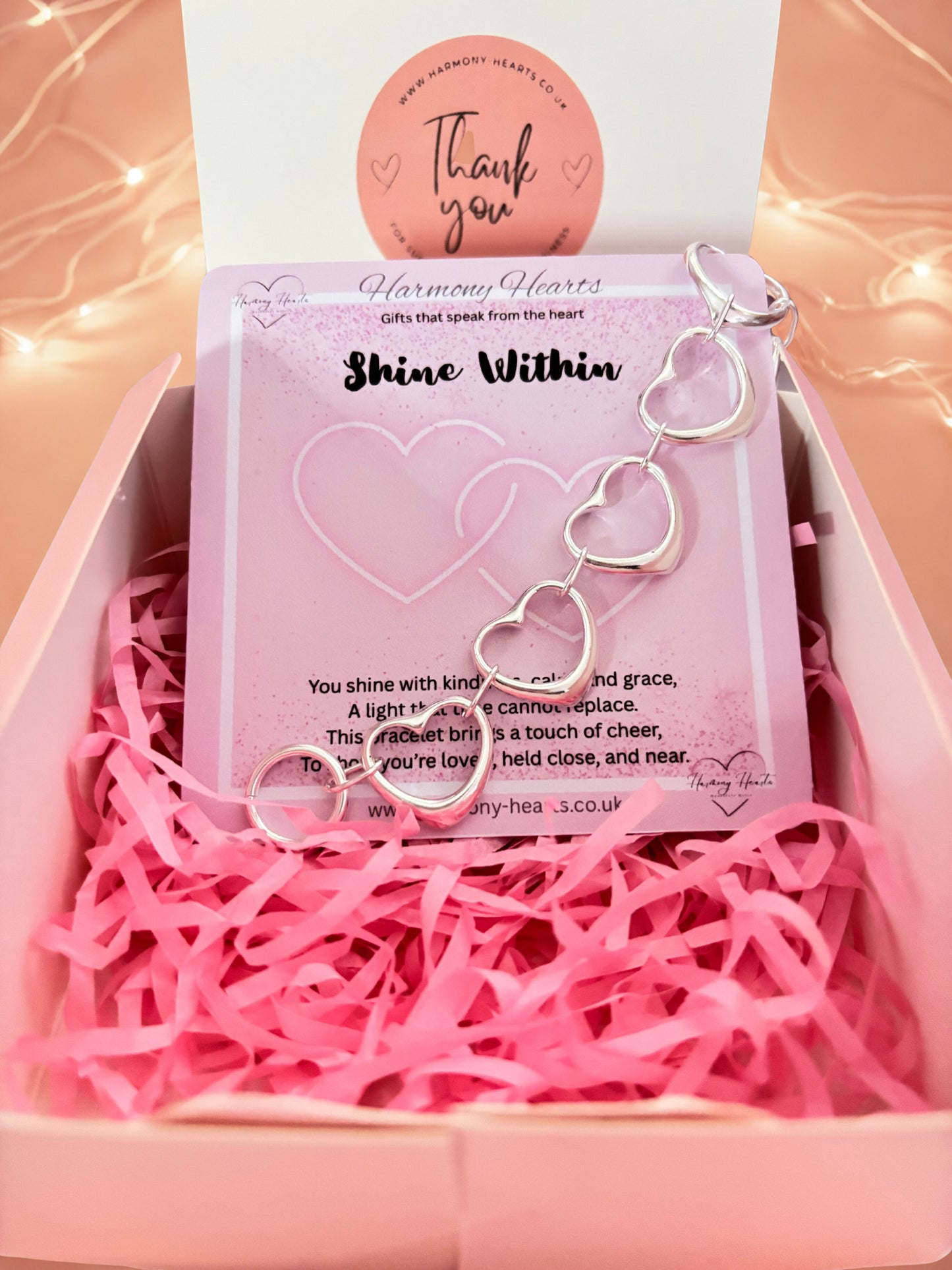 Heart-shaped bracelet in a pink box with a 'Thank you' card and 'Harmony Hearts' branding.