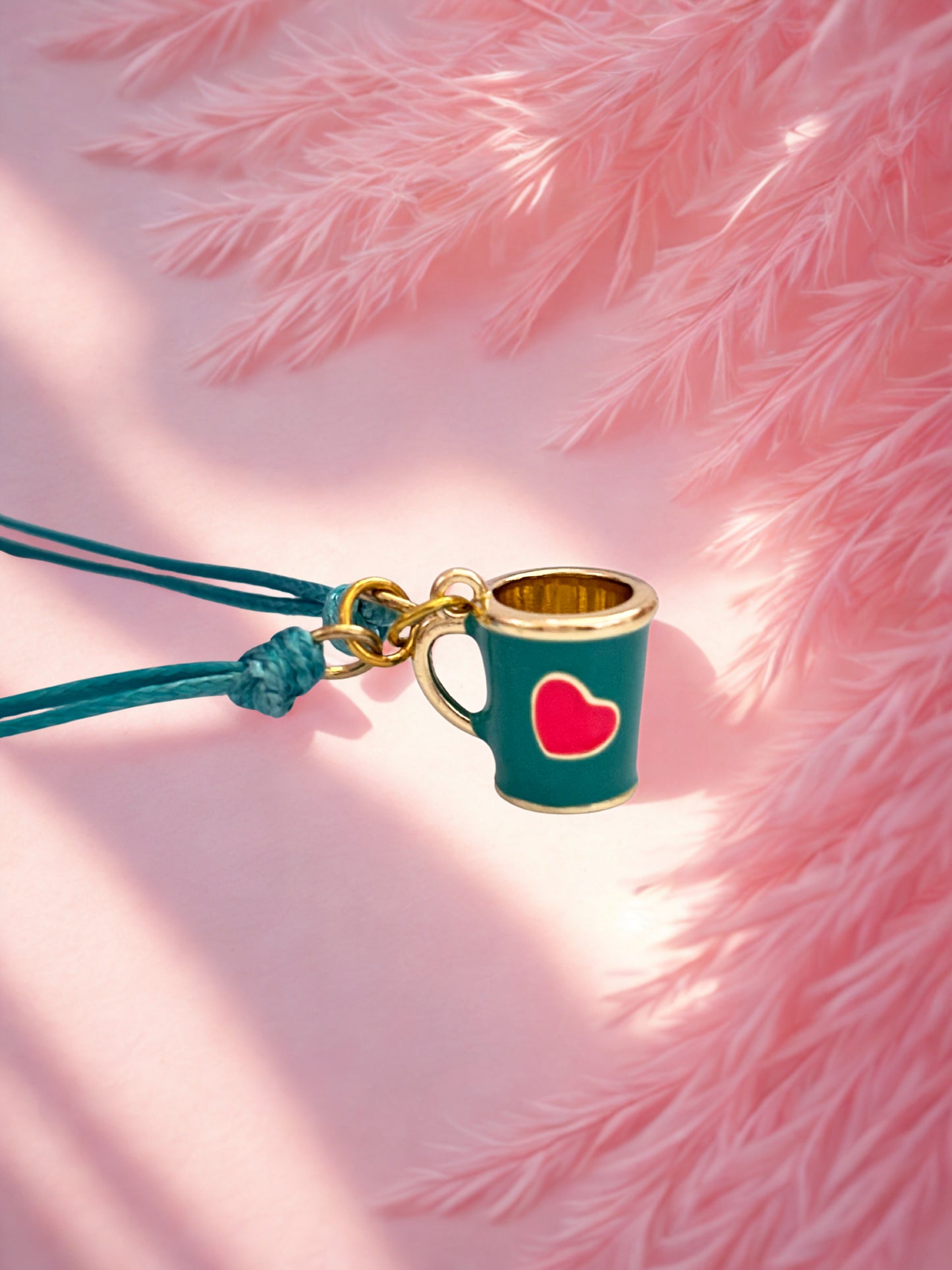 Tea cup charm bracelet with a heart on a pink fluffy background