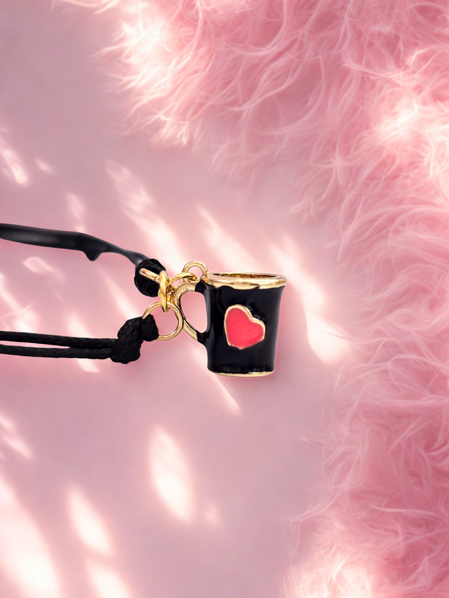 Bracelet with Black mug-shaped charm with a red heart on a pink textured background