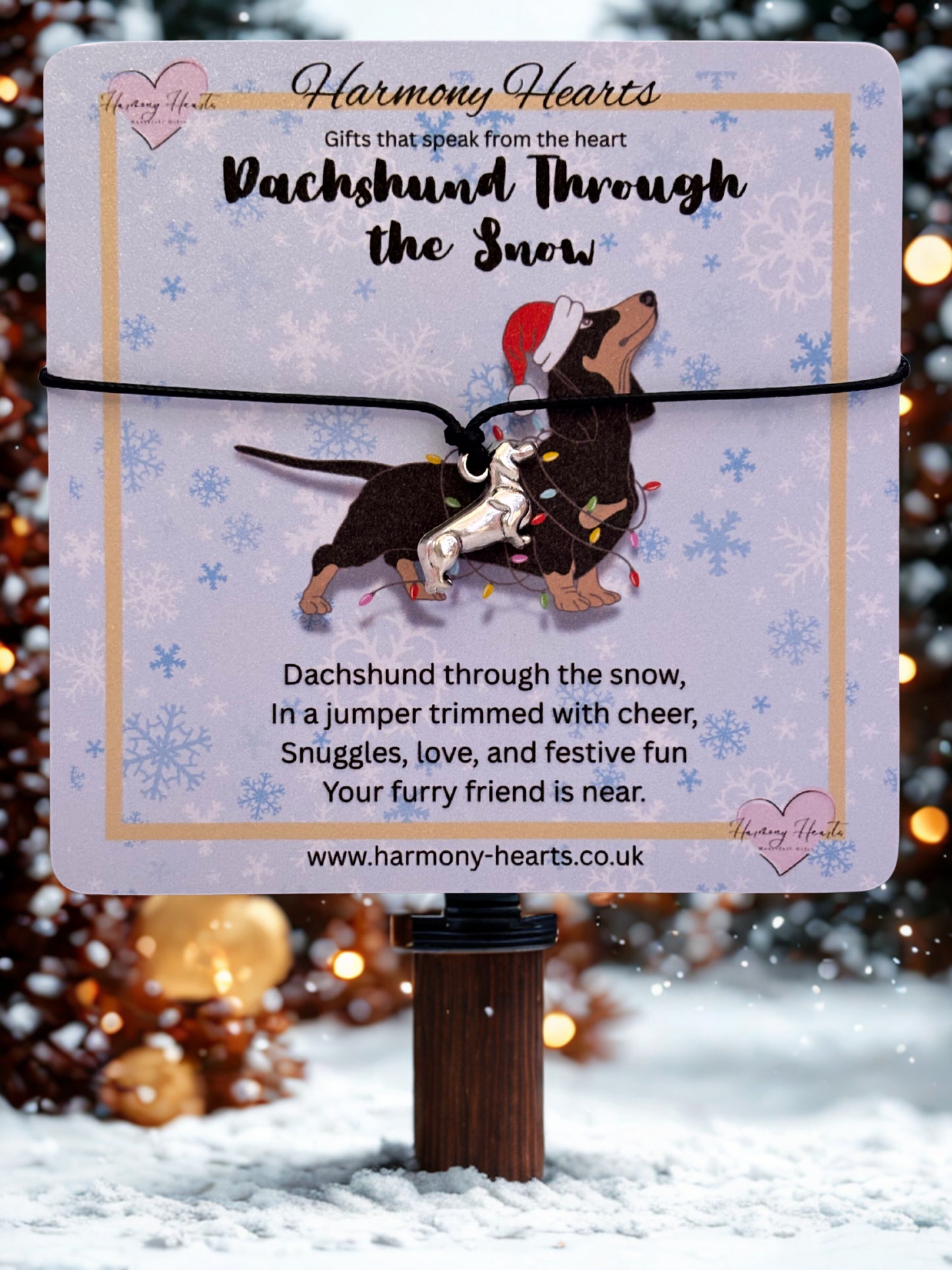 Dachshund-themed bracelet with decorative packaging on a snowy background