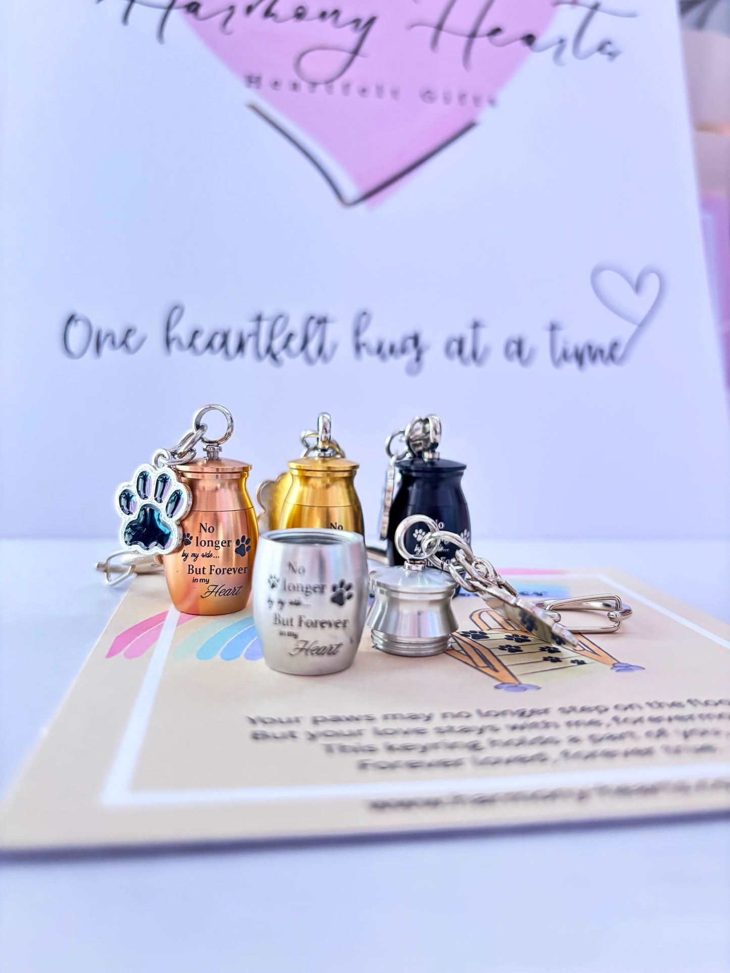 Set of pet memorials including urns and keychains on a card with text.