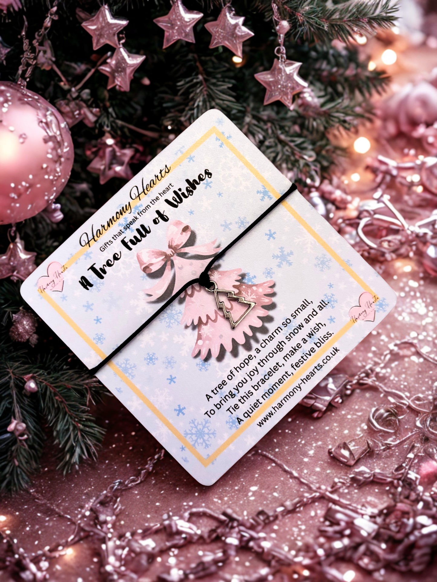 Silver-tone Christmas tree charm on a black cord bracelet on a festive poem card