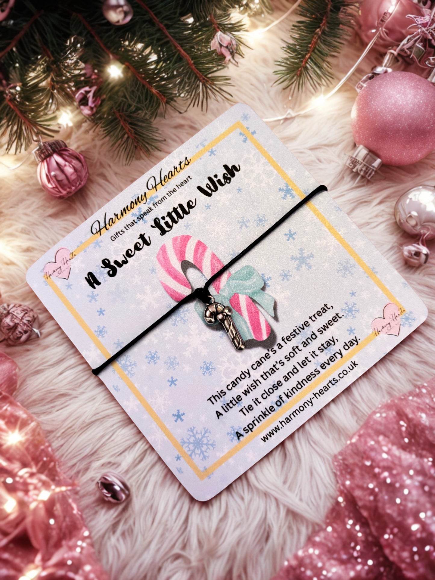 Silver-tone candy cane charm on a black cord bracelet on a festive poem card