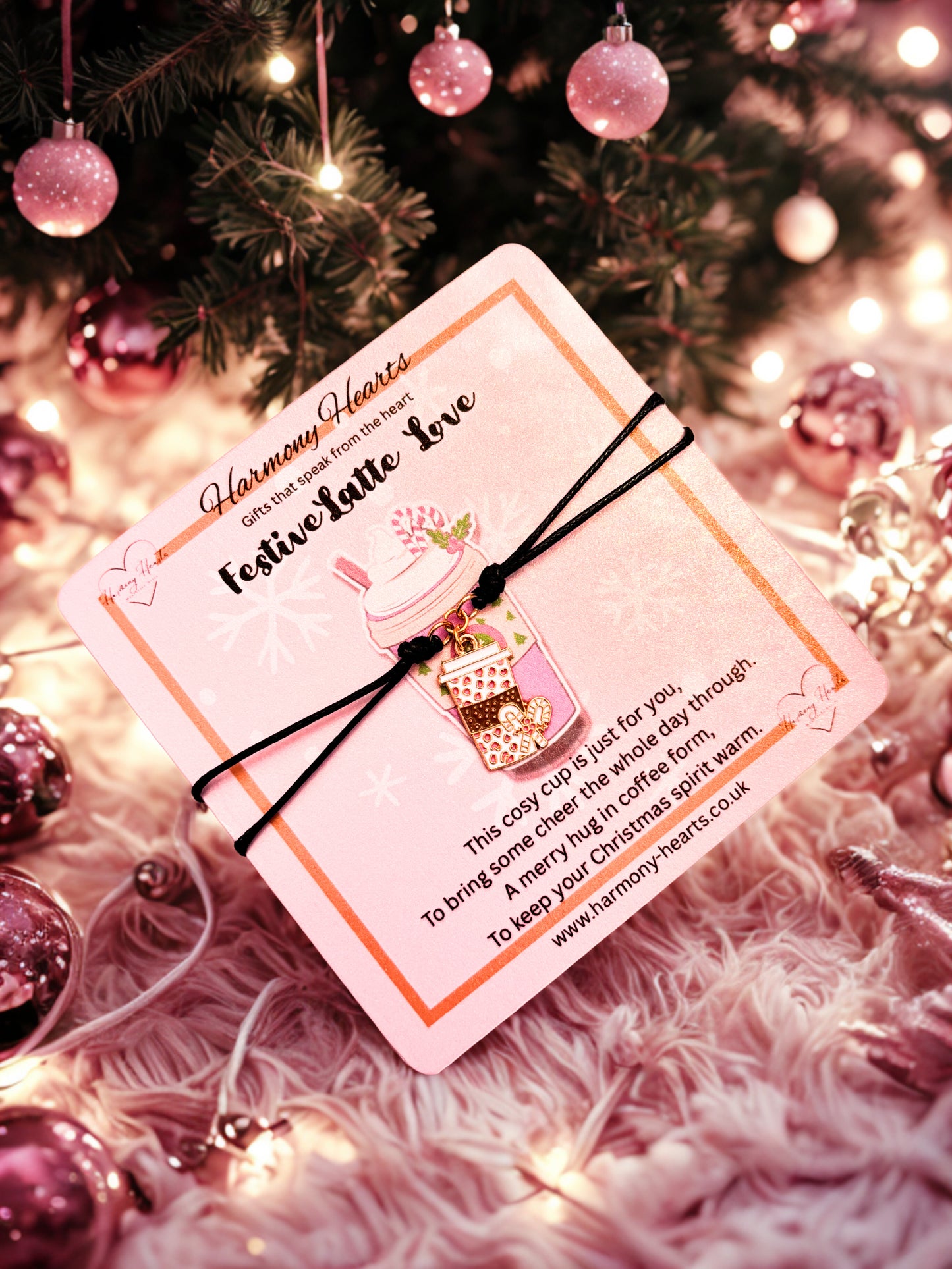 Coffee cup bracelet on a poem card on a Christmas-themed background with ornaments and lights.