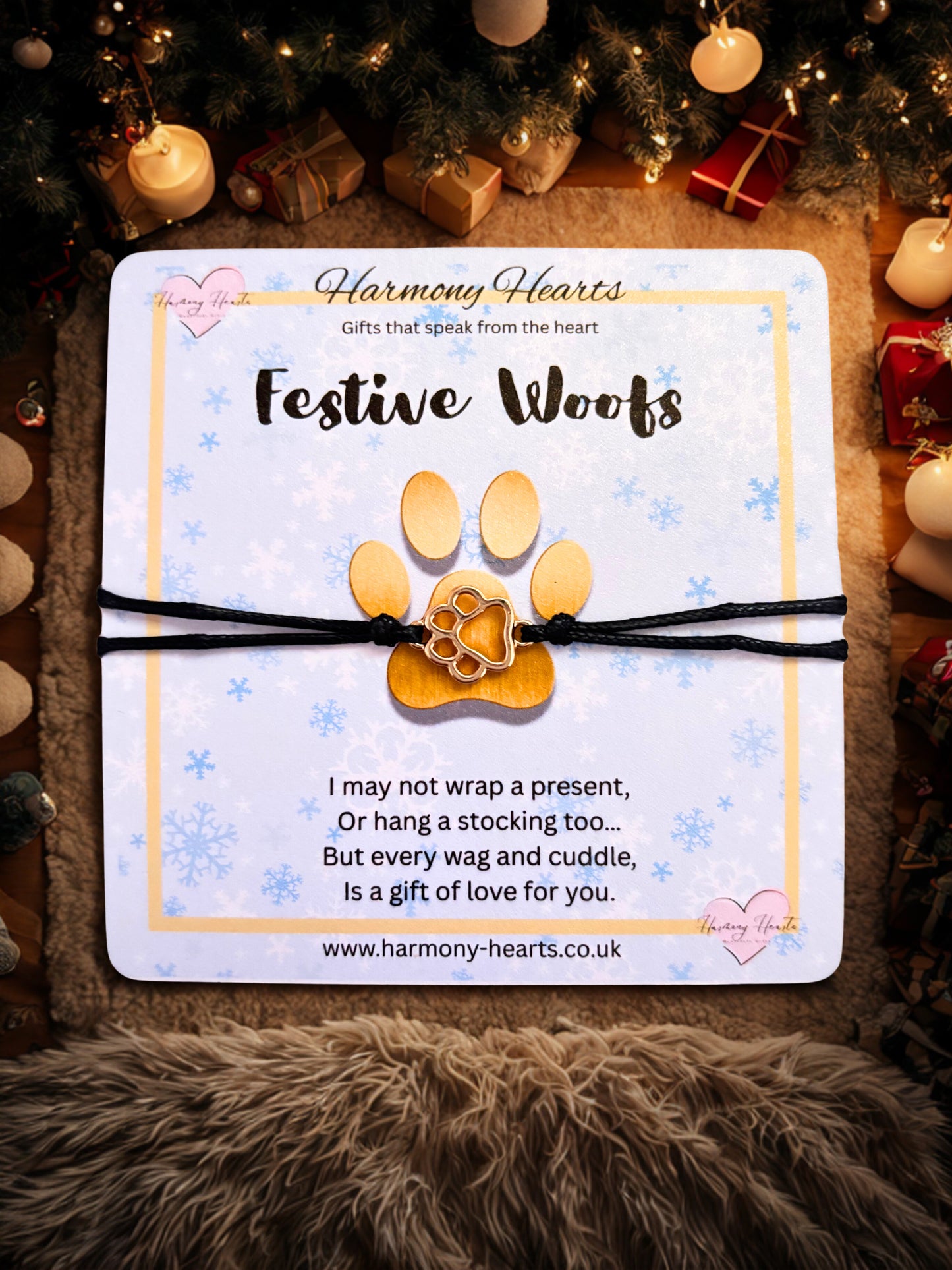 FestiveWoofs paw print bracelet on a card with Christmas decorations in the background