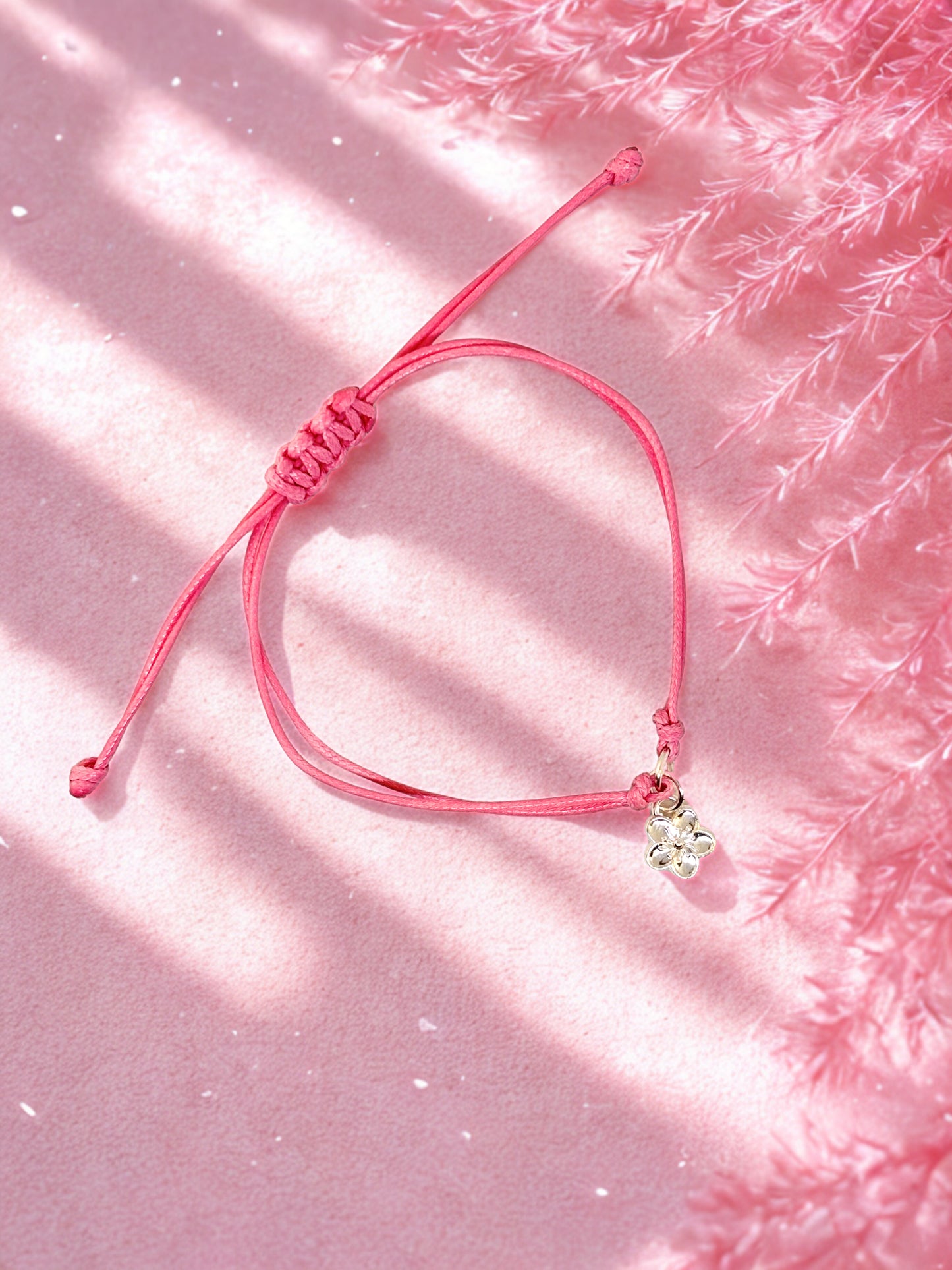 Pink cord charm bracelet with silver flower charm