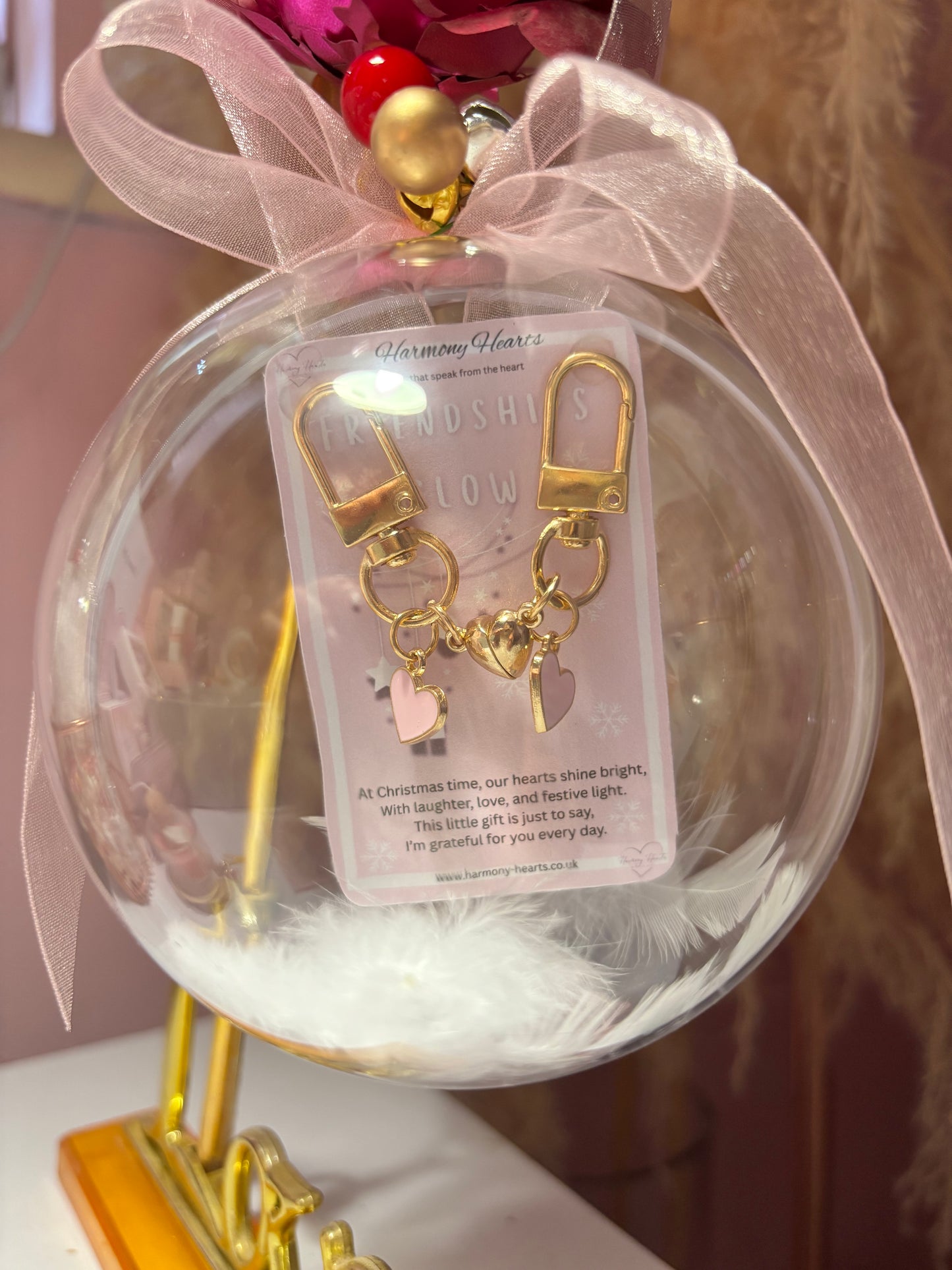 Gold keychain with heart charm in a decorative glass ball with pink ribbon