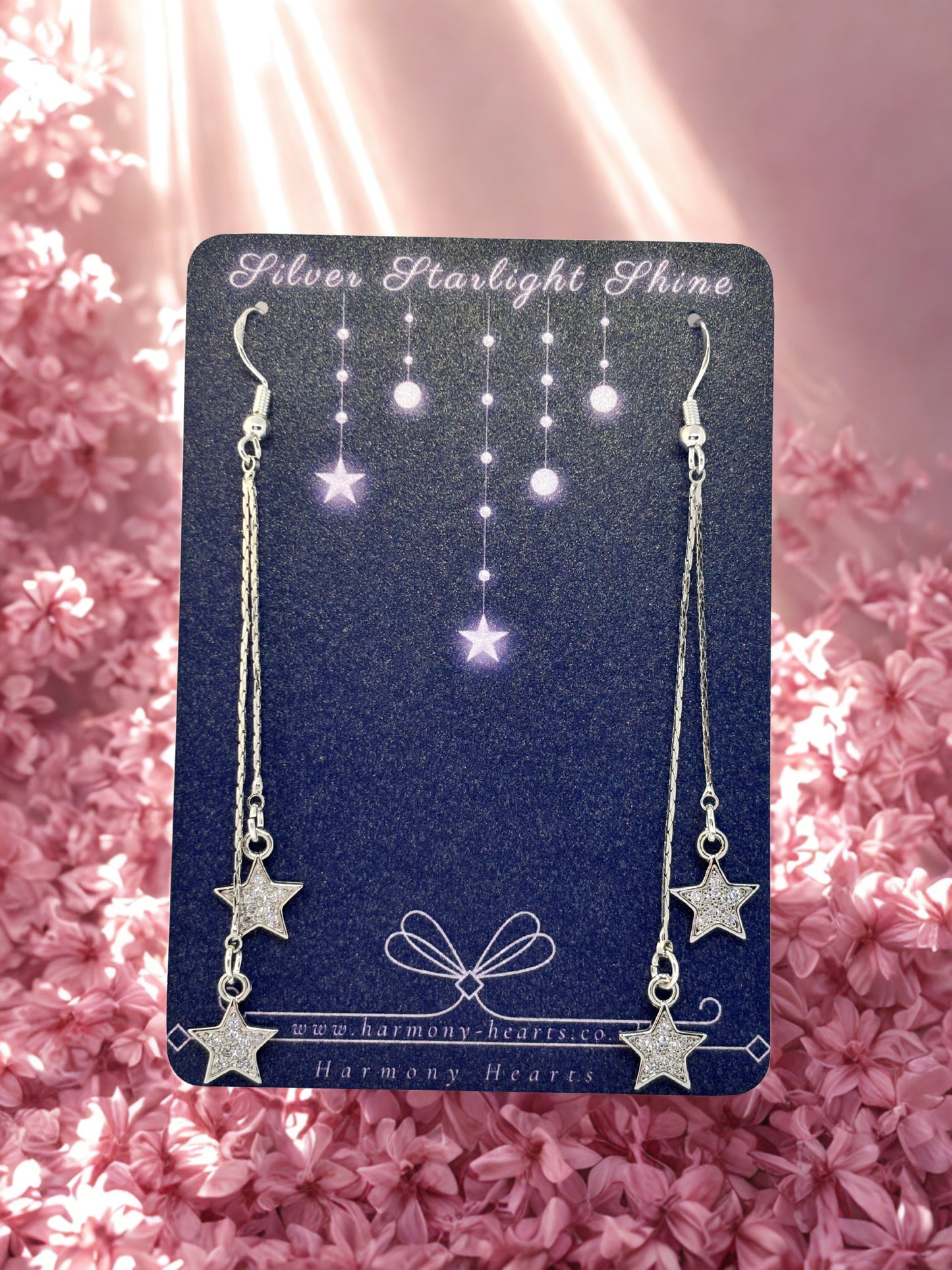 Star-shaped earrings on a 'Silver Starlight Shine' card with a pink floral background