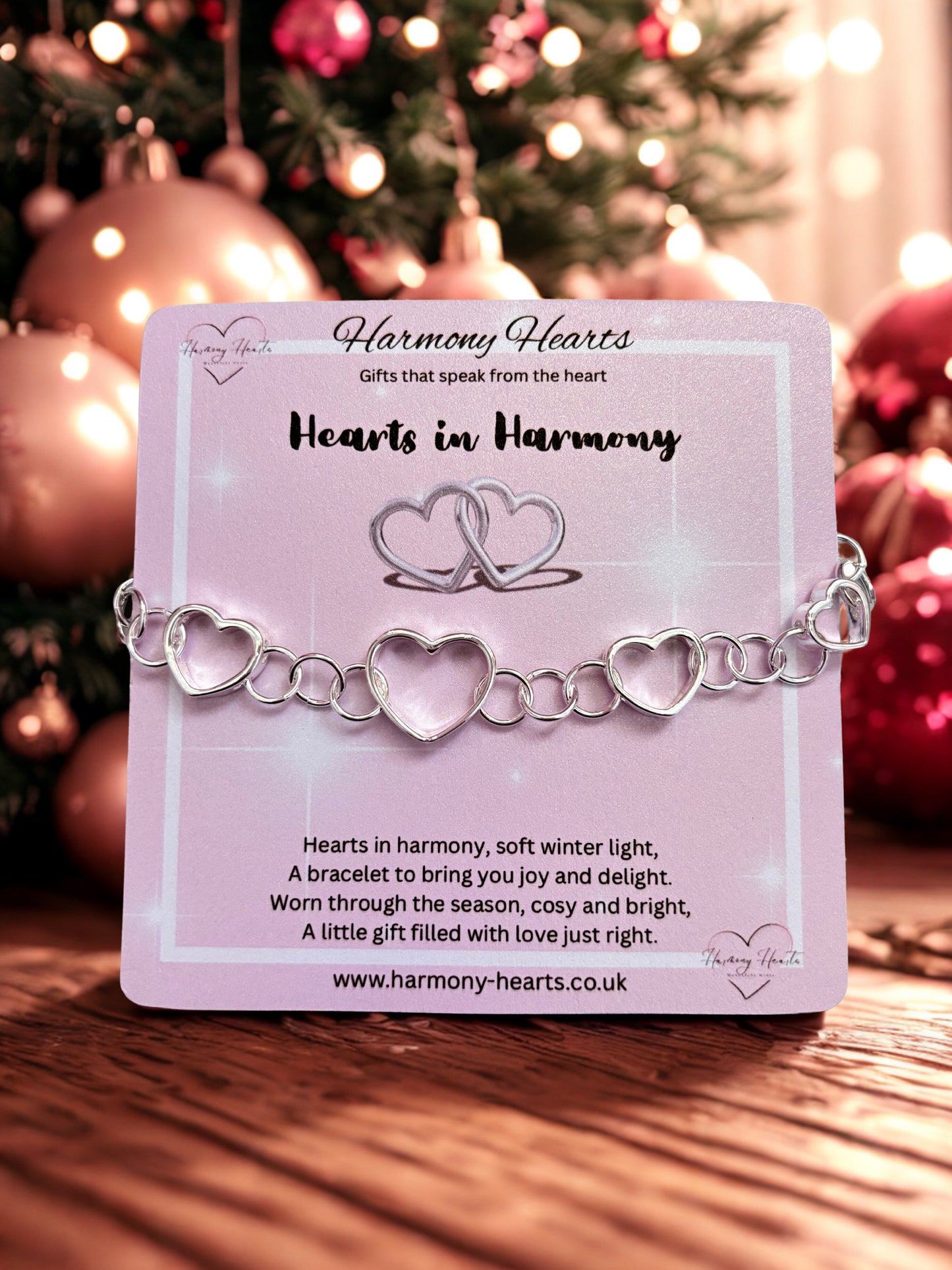 Heart-shaped bracelet on a card with Christmas decorations in the background