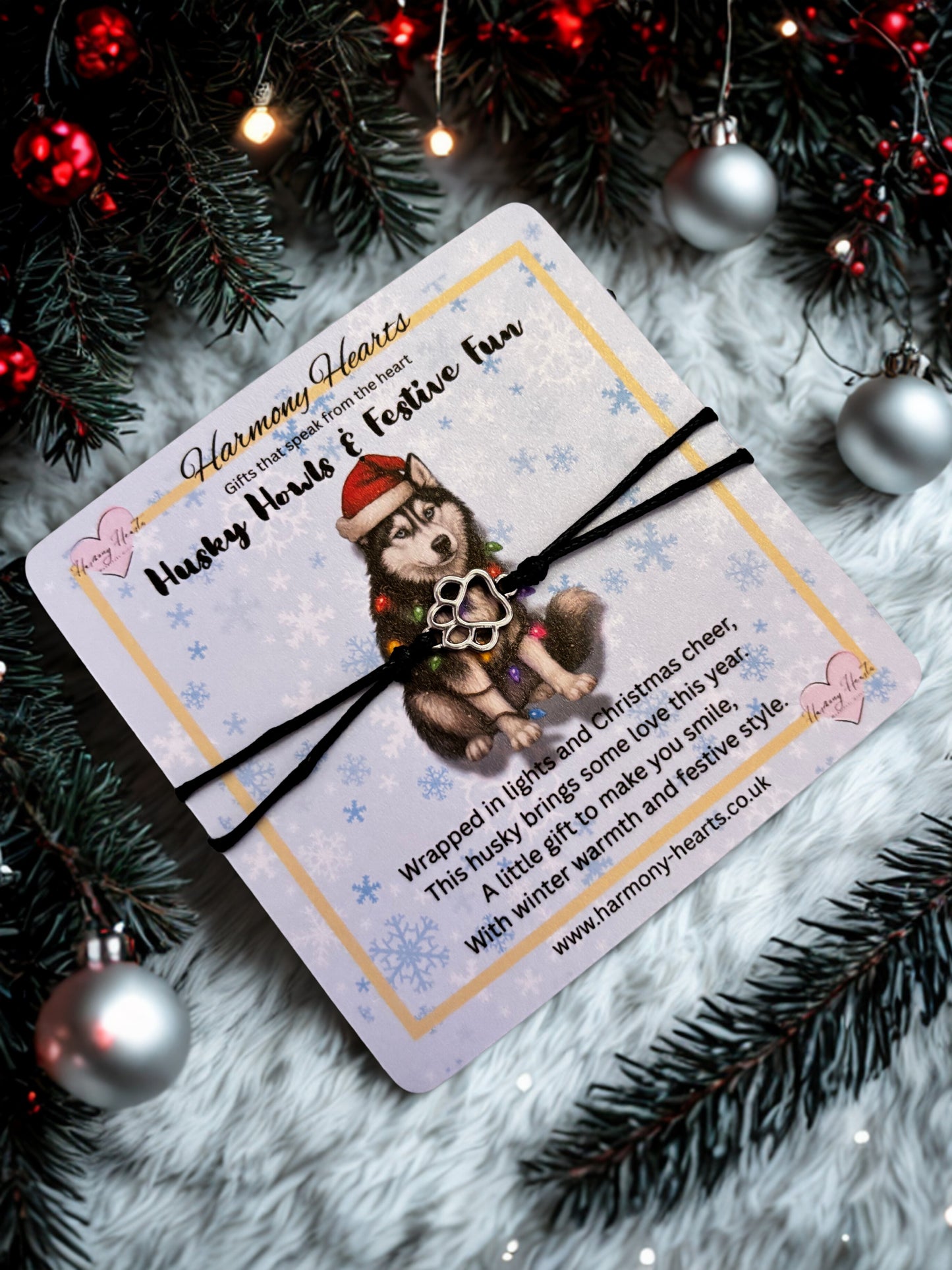 Gift card with a husky design and bracelet on a festive background with Christmas decorations.