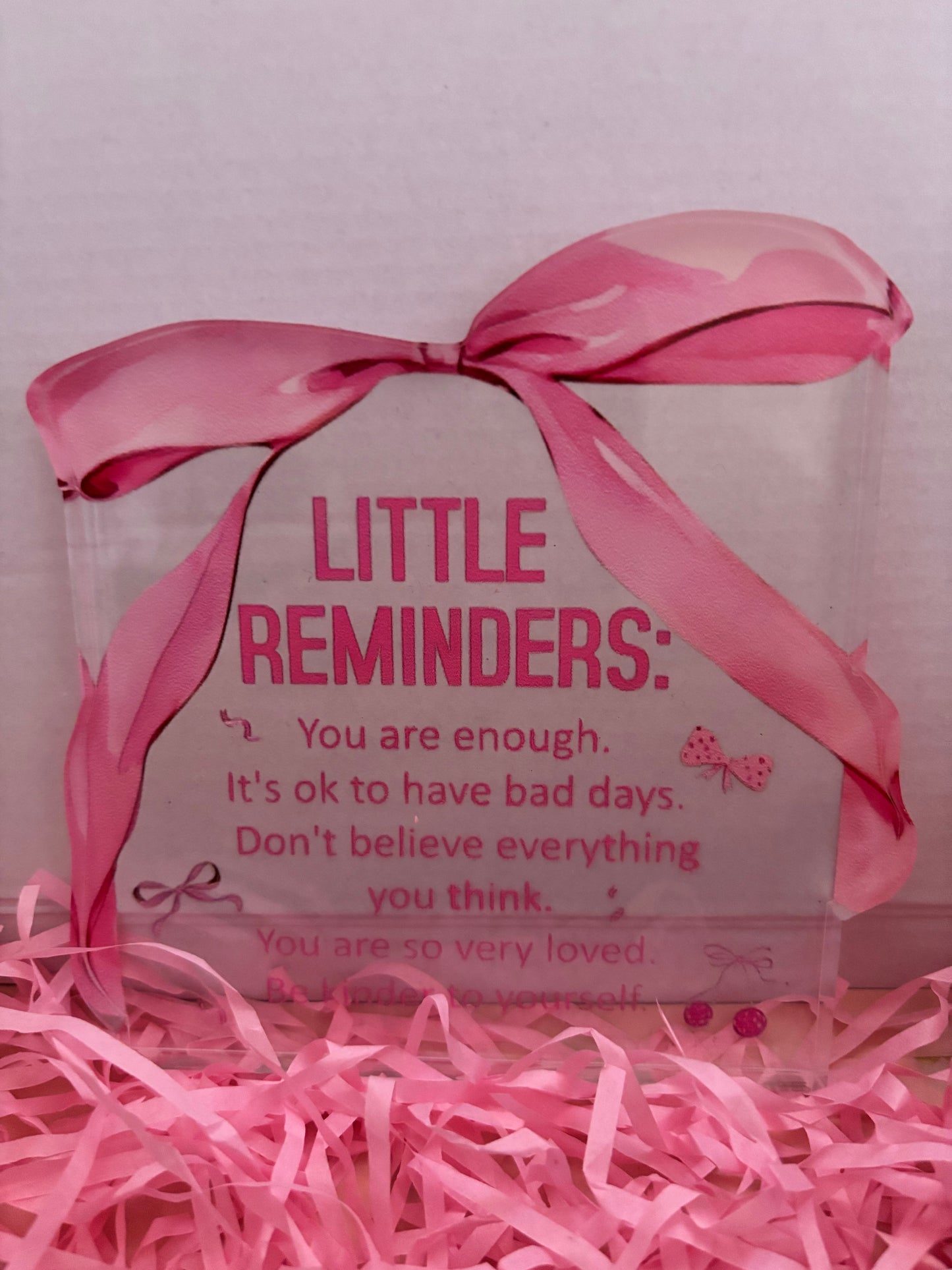 Decorative box with pink ribbon and motivational message on a pink background