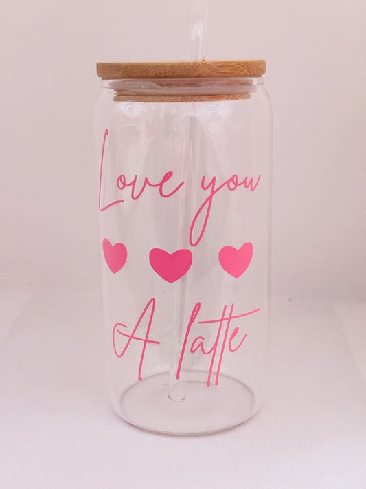 Clear glass tumbler with wooden lid, pink text 'Love you a latte' and hearts on a light pink background