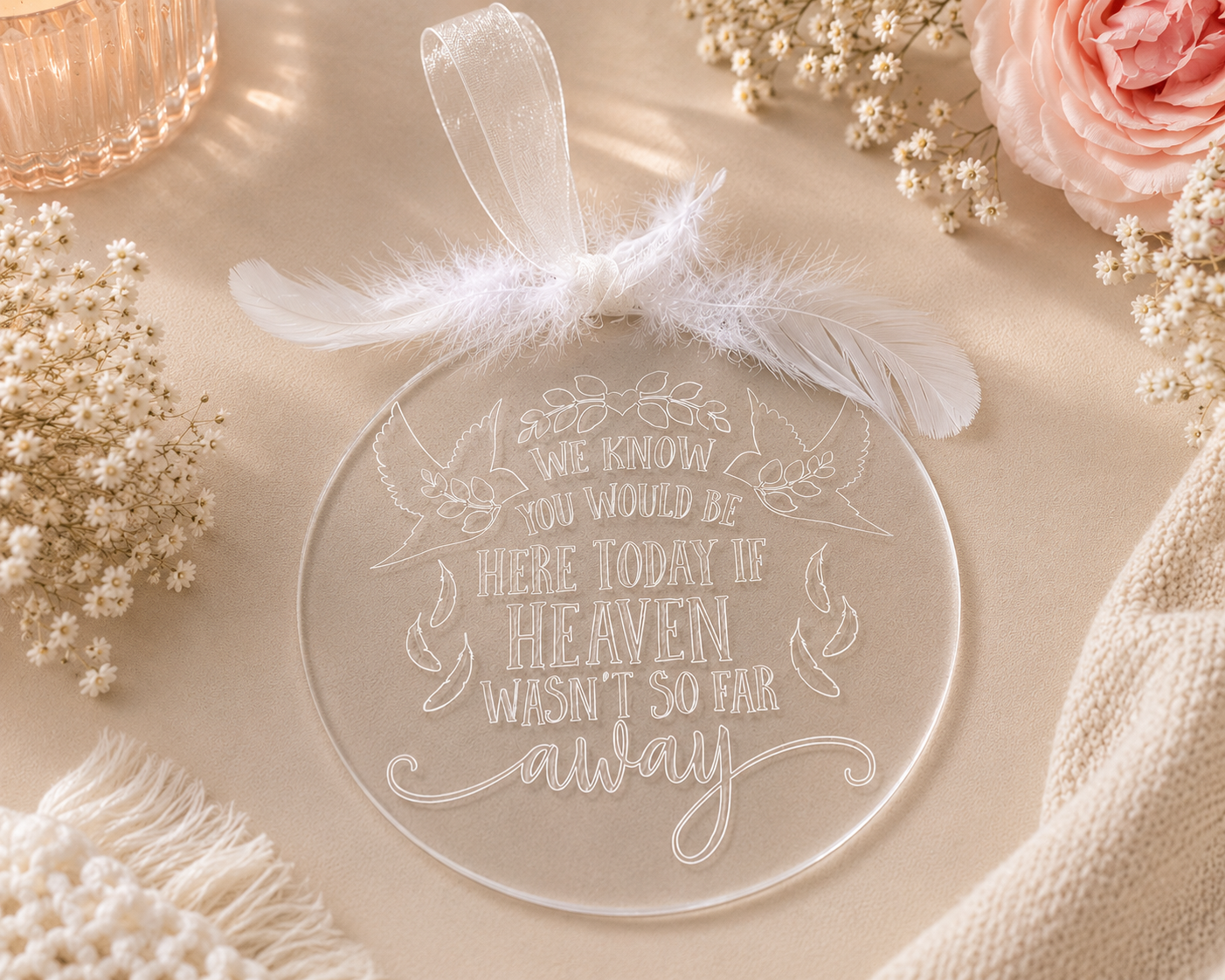 Memorial plaque with feathers and ribbon with the words, we know you would be here if heaven wasn’t so far away