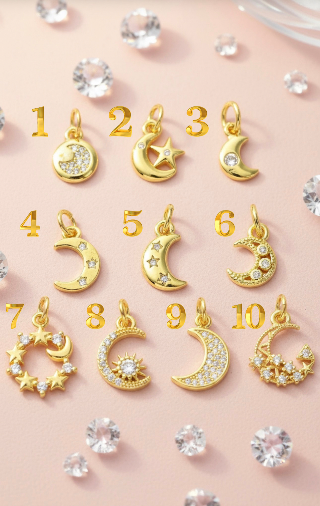Gold moon and star pendants with clear gemstones on a pink background