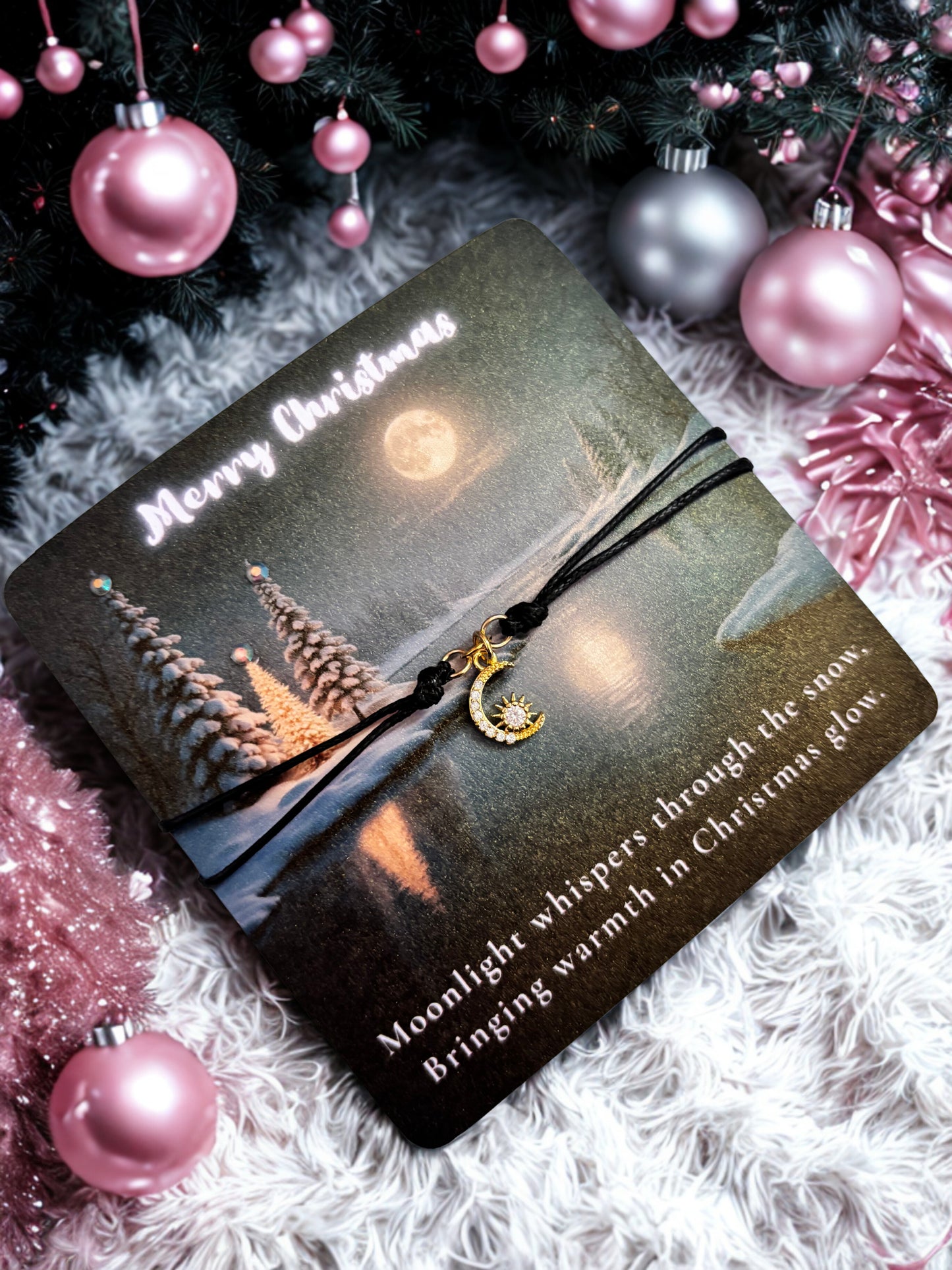 Gift card with Christmas design and text, and a gold moon charm bracelet surrounded by festive decorations.
