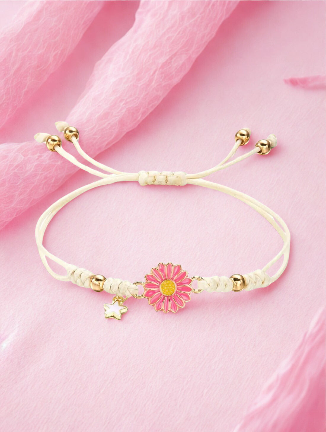 Bracelet with a pink flower charm on a pink fabric background