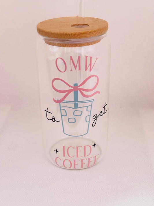 Glass tumbler with wooden lid featuring text and a graphic of iced coffee.