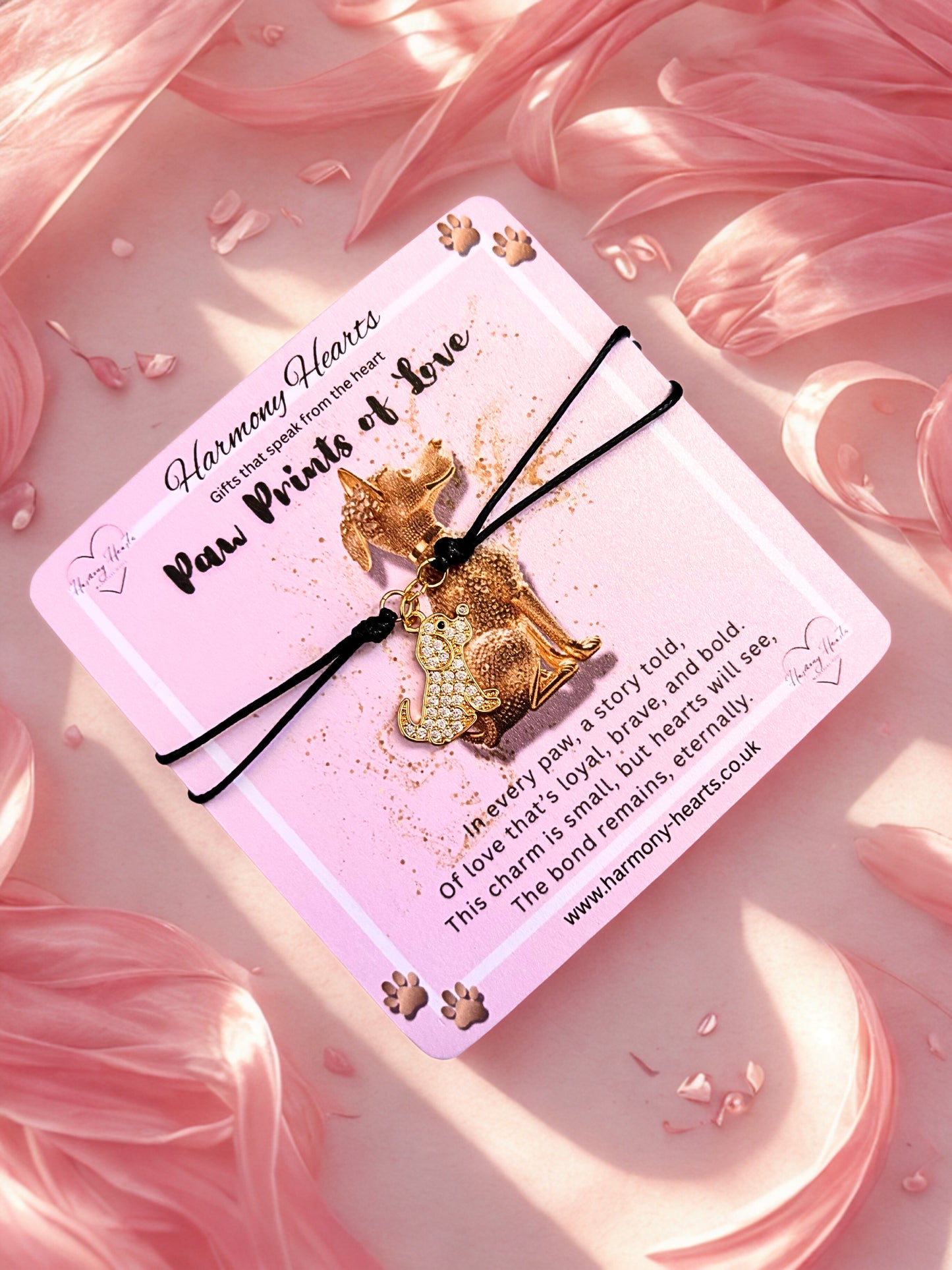Gold dog-shaped charm on a pink card with decorative elements