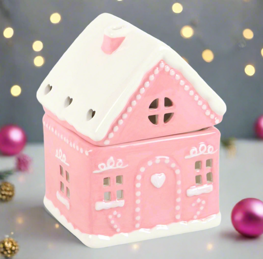 Pink house-shaped lantern with decorative elements on a blurred background with lights and ornaments.