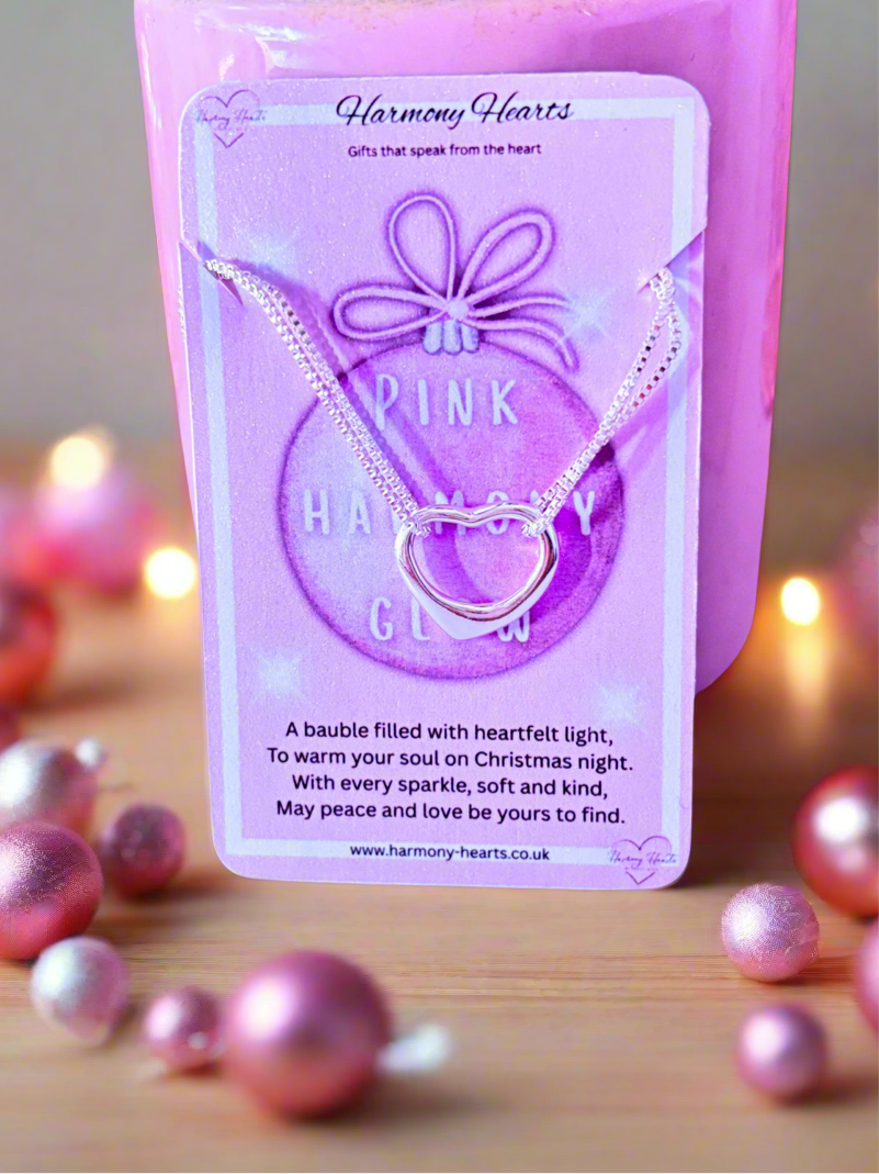 Pink 'Harmony Hearts' bracelet packaging with pink baubles on a wooden surface.