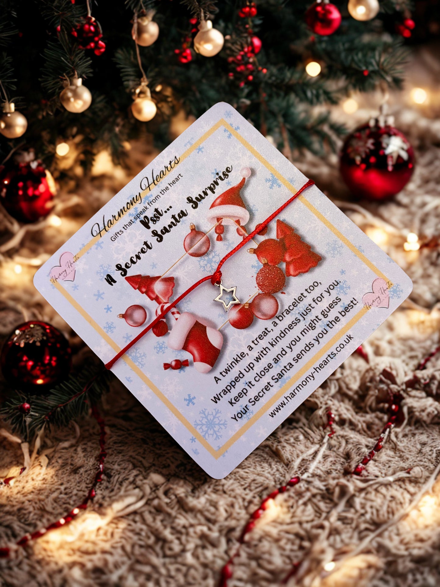 Card with Santa Claus design and a star charm bracelet on a Christmas-themed background