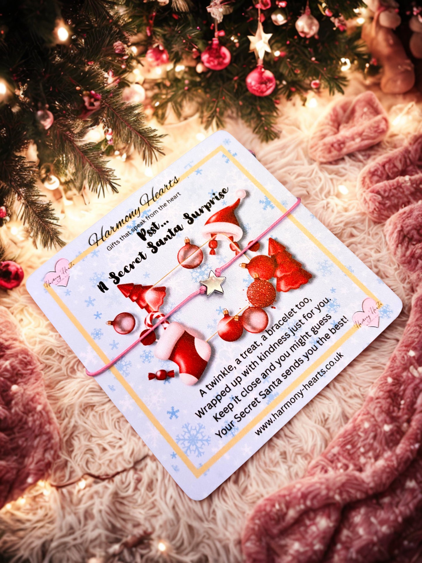 Bracelet with Secret Santa card with red hats and presents under a Christmas tree