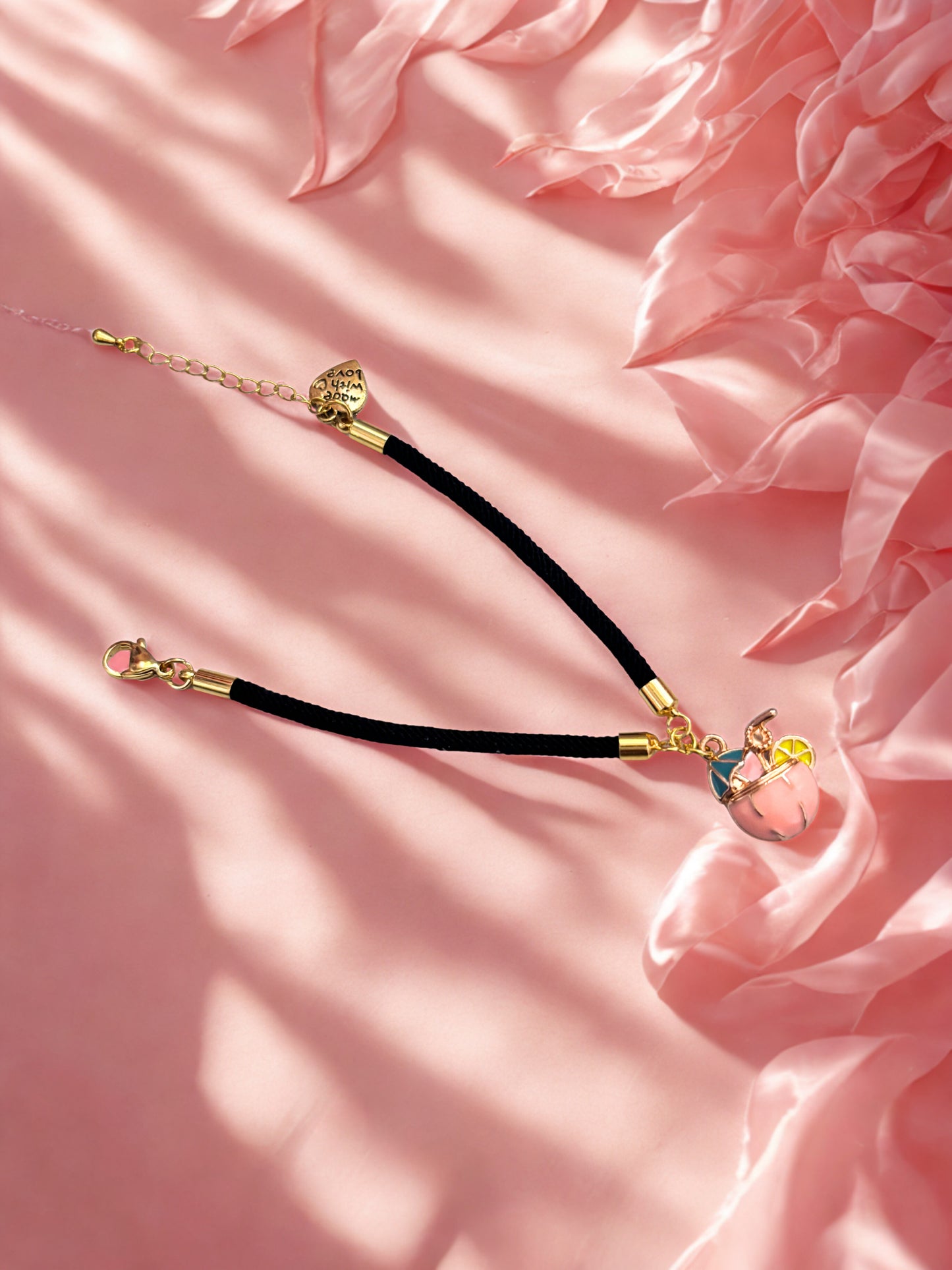 Black charm bracelet with pink cocktail charm