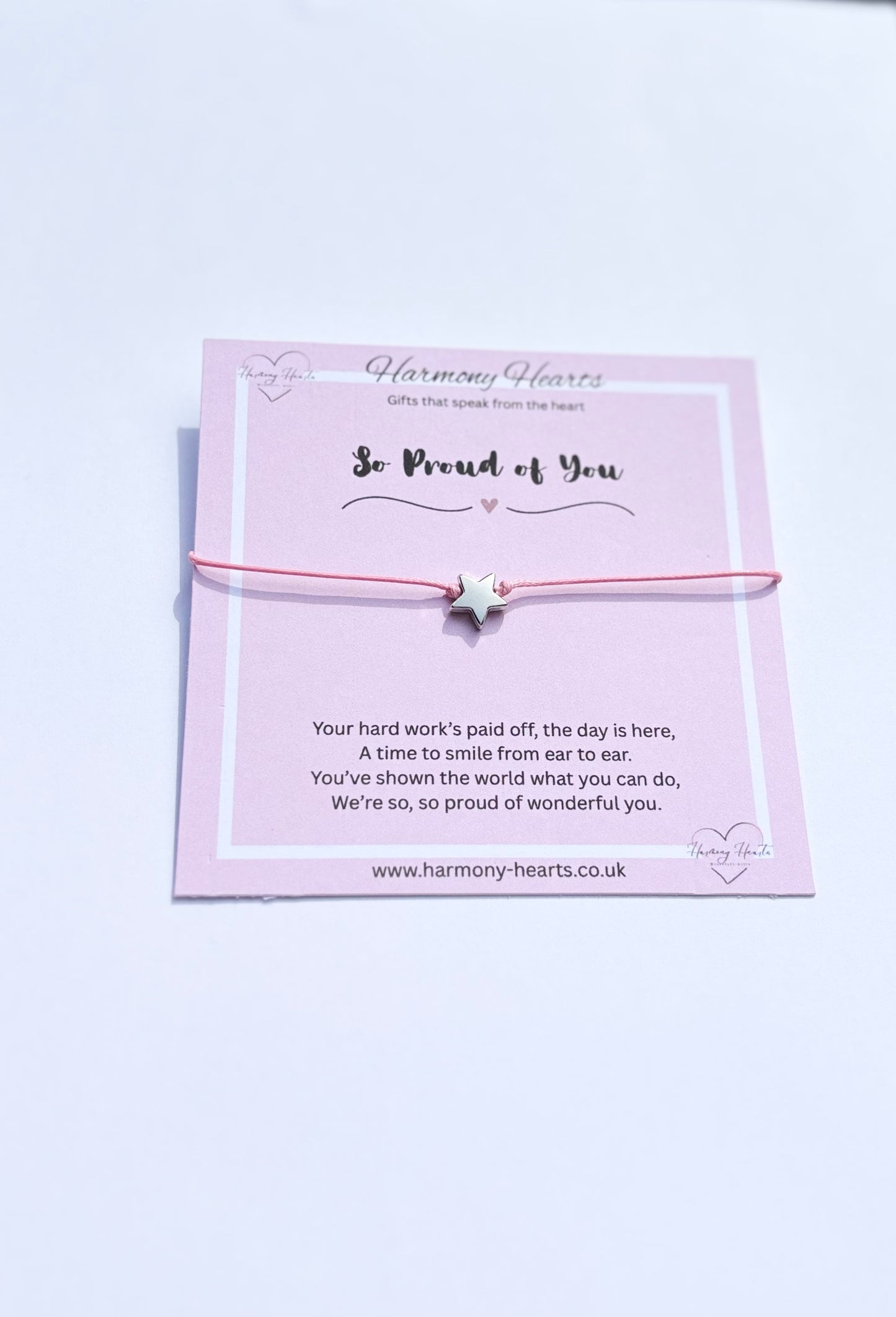 Pink bracelet with a message card on a white background