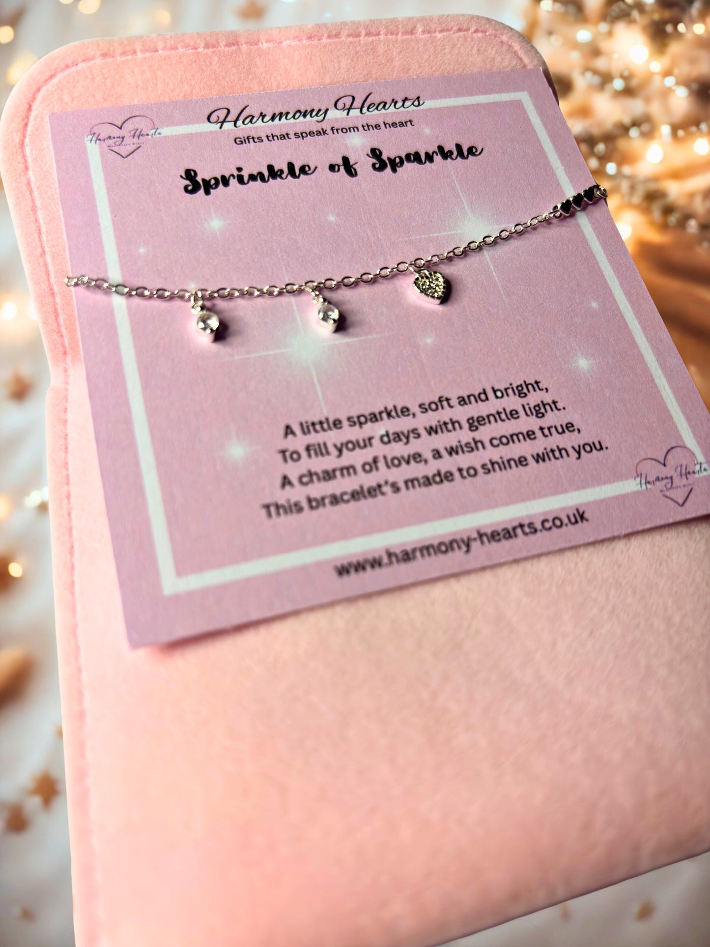 Bracelet with heart-shaped charms on a pink card with 'Harmony Hearts' branding.