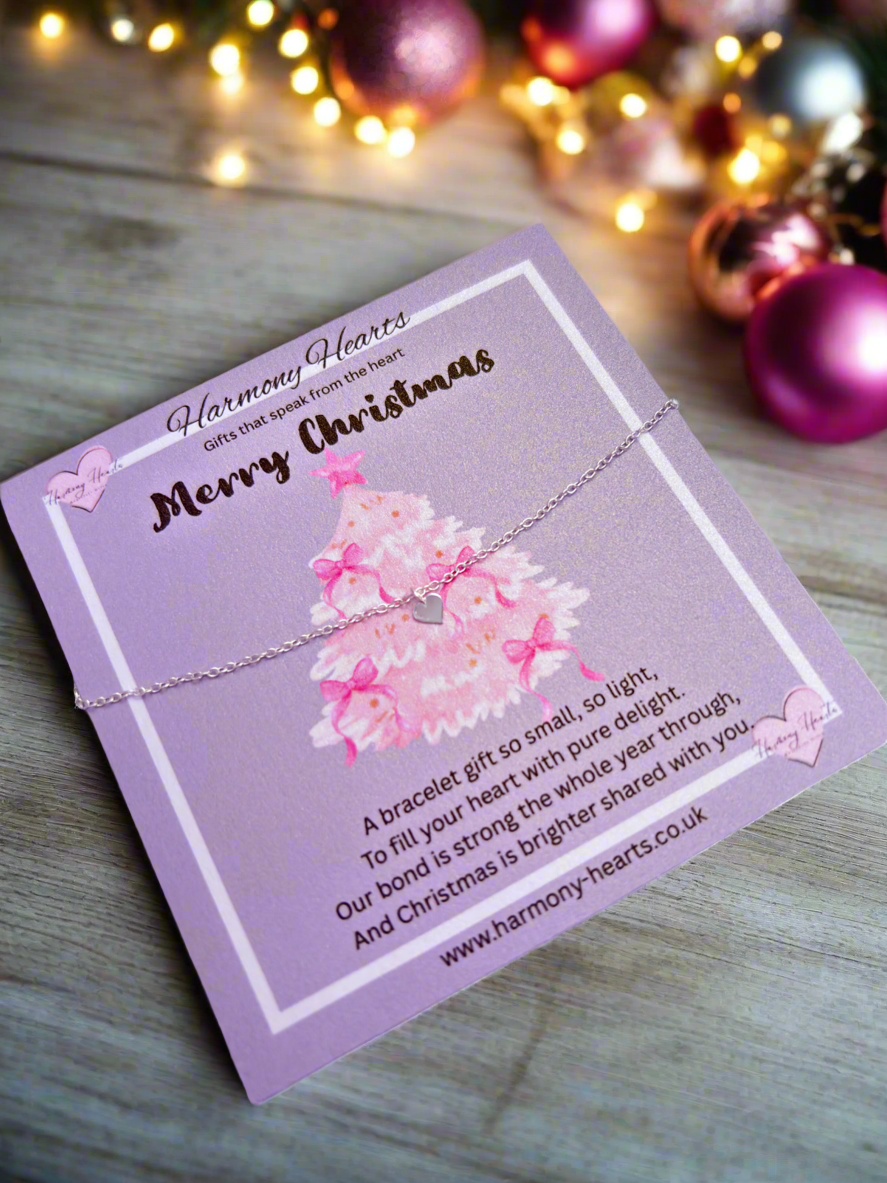 Pink bracelet with floral design on a card with 'Harmony Hearts' branding, set against a festive background.
