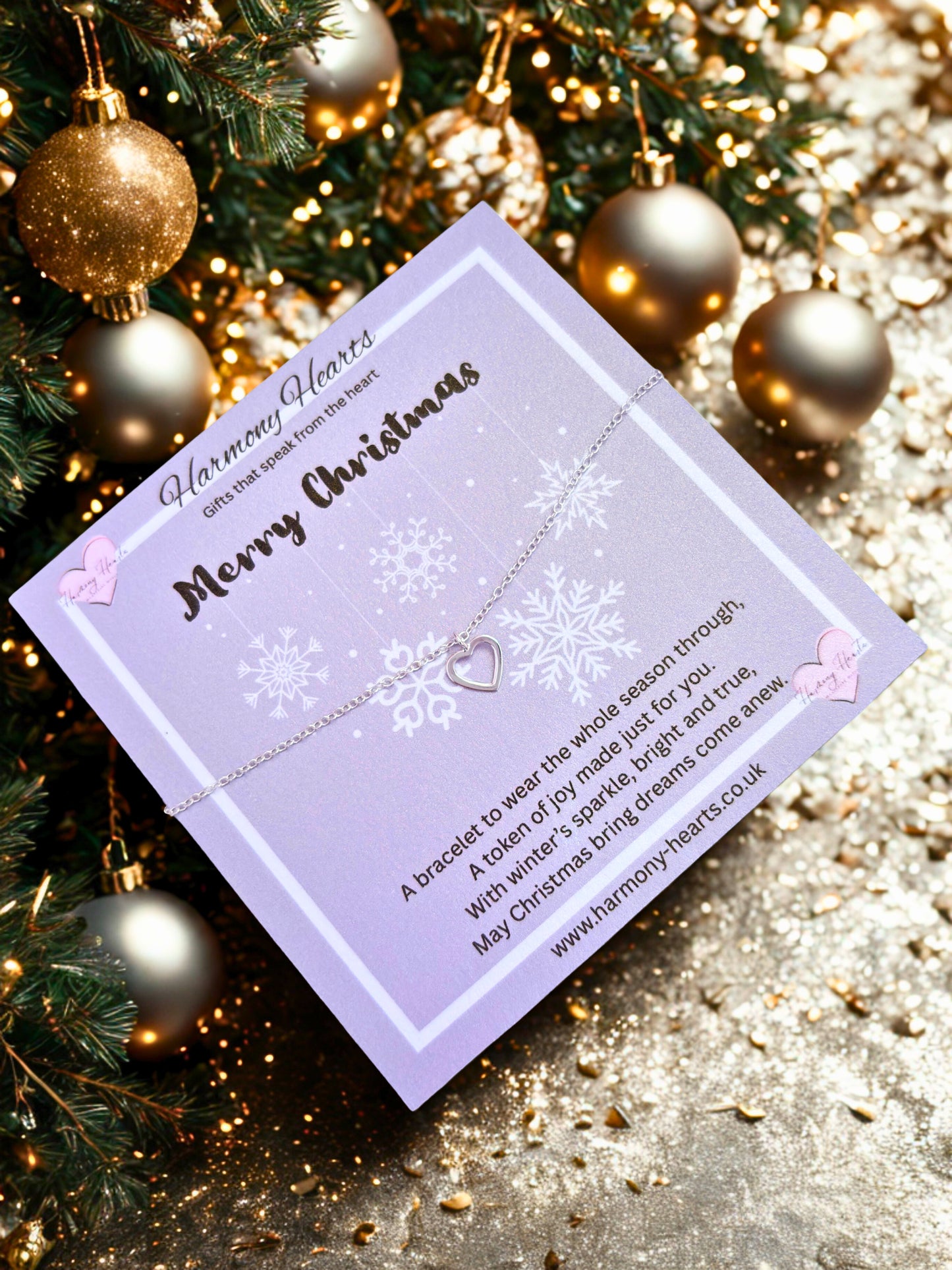 Bracelet with heart charm on a purple card with Christmas decorations in the background