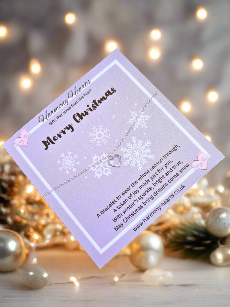 Bracelet with heart charm on a decorative card with Christmas lights in the background