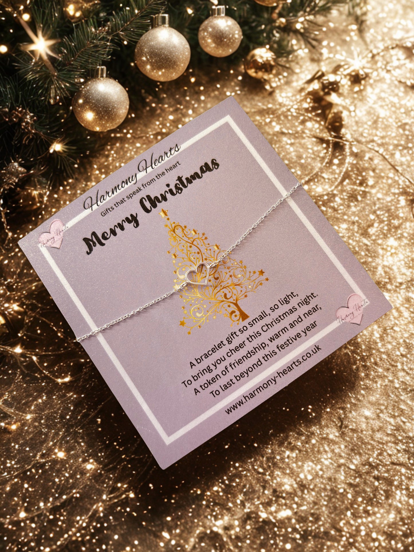 Silver bracelet on a Christmas-themed card with gold baubles in the background