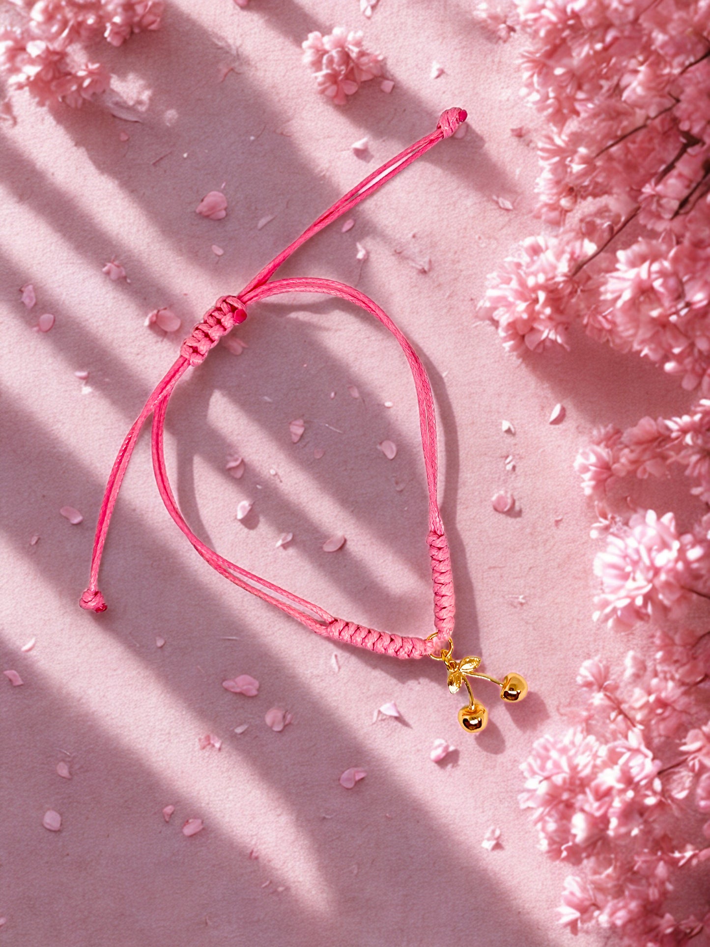 Pink cord bracelet with gold cherry charm