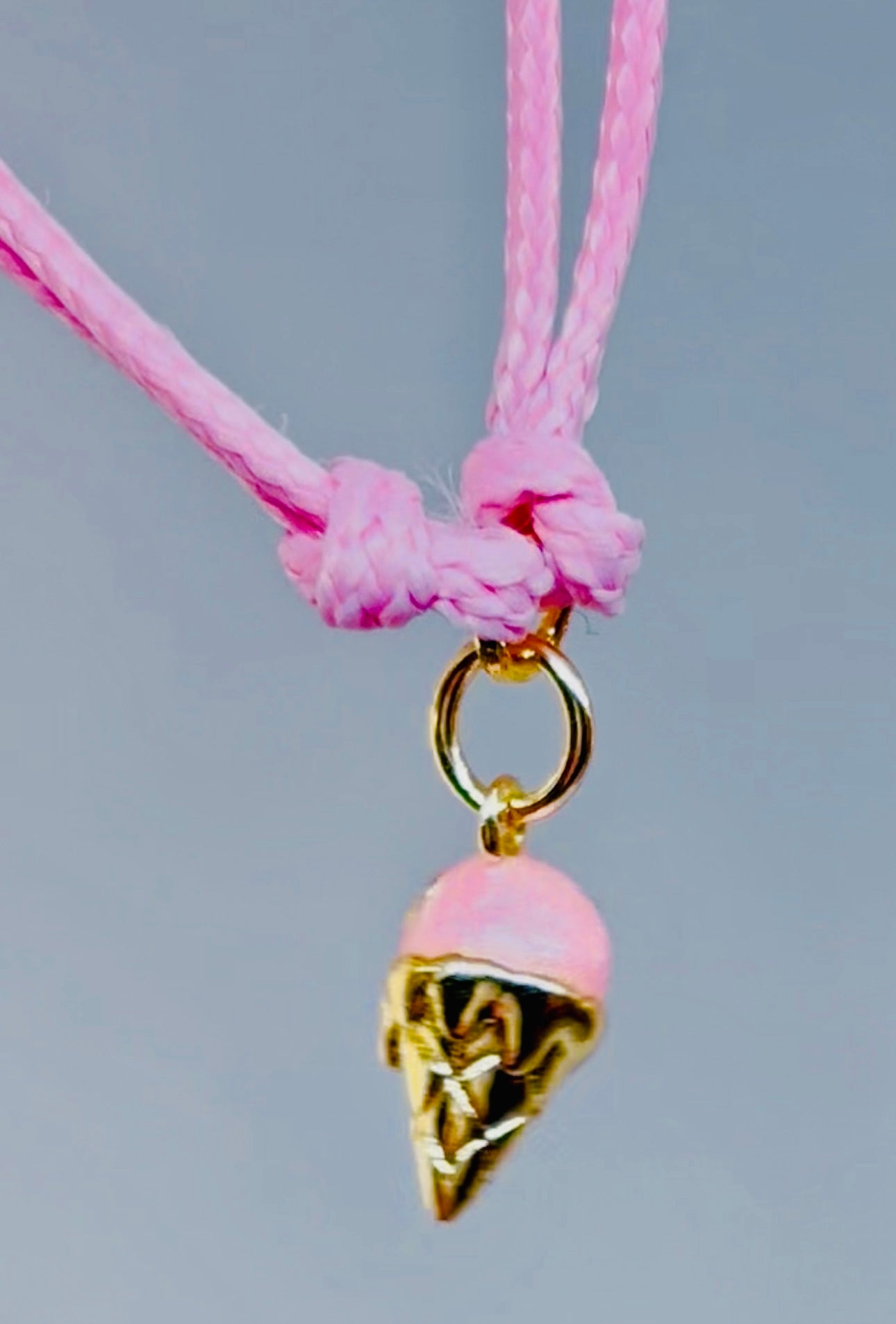 Pink and gold ice cream charm on a pink cord bracelet